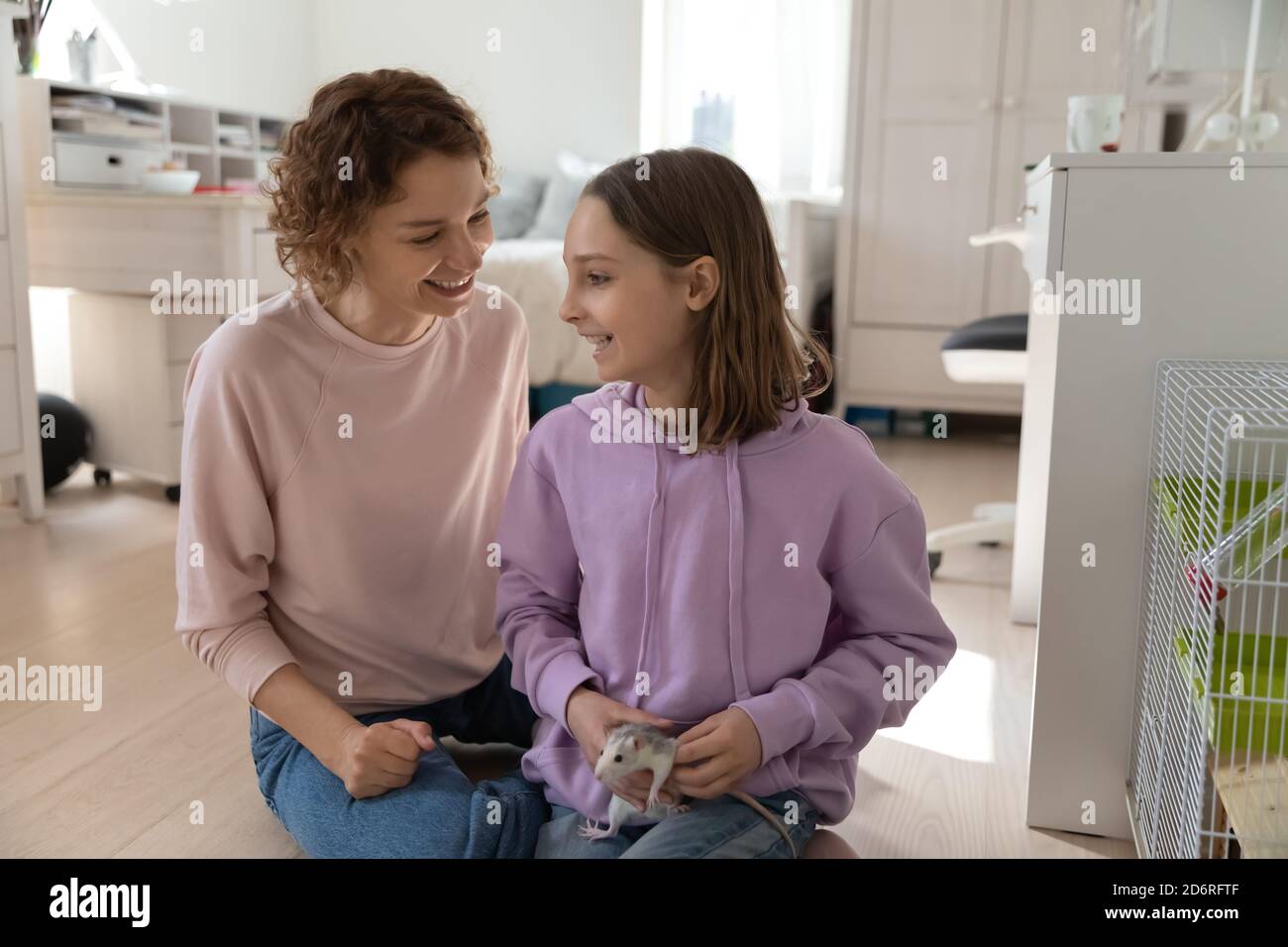 Bonne maman et fille de l'adolescence jouent avec la souris domestique Banque D'Images