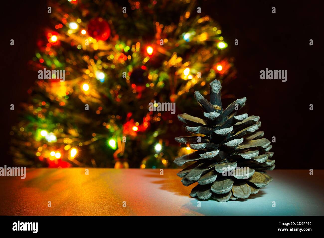 Cône de sapin sur fond d'arbre de noël avec guirlande lumineuse. Copier le texte, sélection Banque D'Images