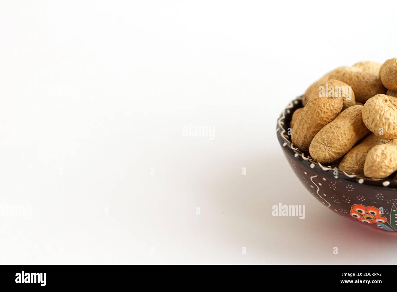 Arachides brutes en coquille sur la tasse sur fond blanc. Copier l'espace pour le texte Banque D'Images