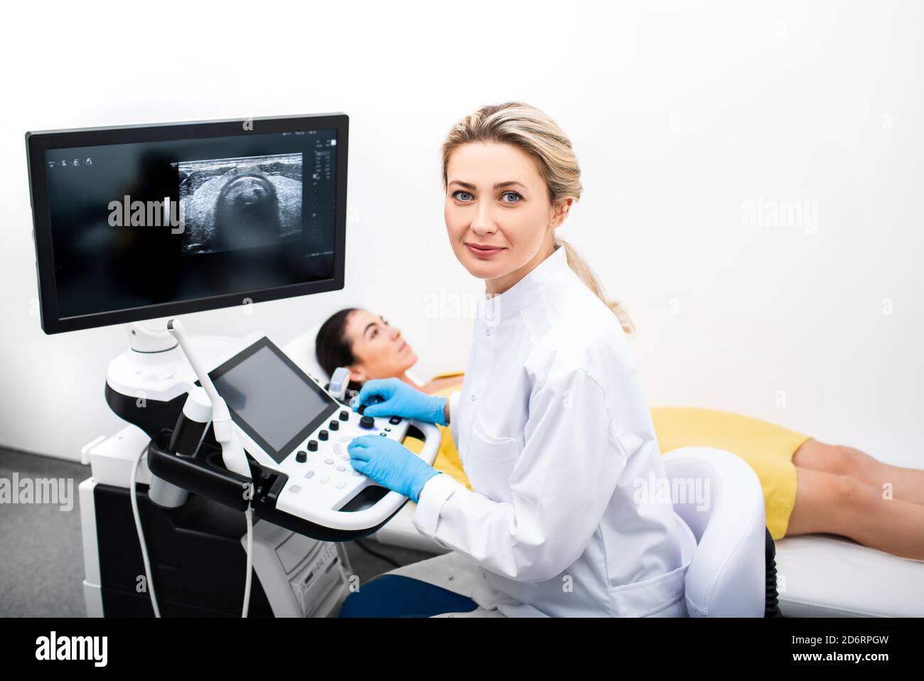 Portrait d'une femme médecin échographé au cours de la procédure d'échographie pour une jeune femme. Diagnostic du système endocrinien à la clinique Banque D'Images