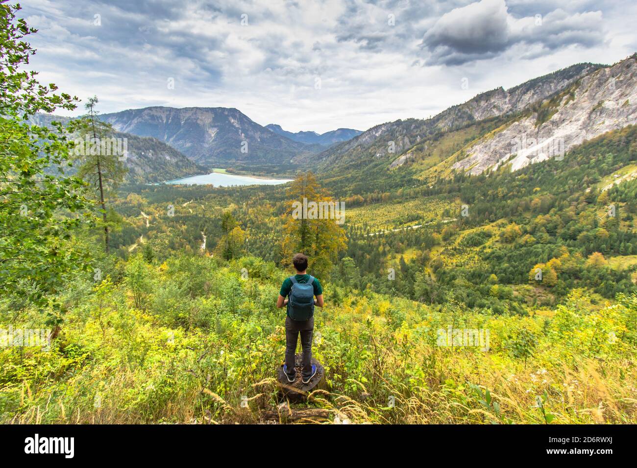 Homme sportif actif ayant un repos sur le pic des Alpes, Autriche. Backpacker offrant une vue sur les montagnes et le lac. Concept de voyage de la liberté de Wanderlust. Banque D'Images