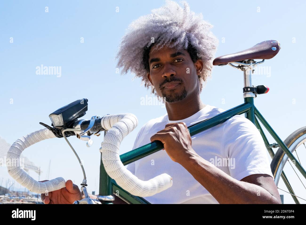 Afro et homme noir portant un vélo de ville sur son dos. Concept de cycliste  et cycliste noir. Parcourez la ville en vélo Photo Stock - Alamy