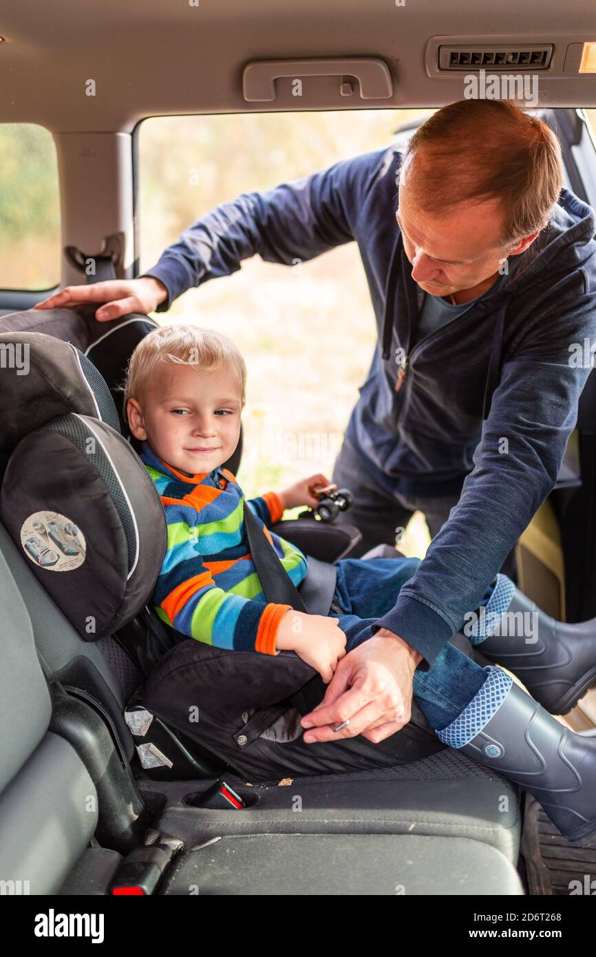 Pere Attachant La Ceinture De Securite De Son Bebe Garcon Dans Son Siege De Voiture Securite Des Sieges D Auto Pour Enfants Photo Stock Alamy