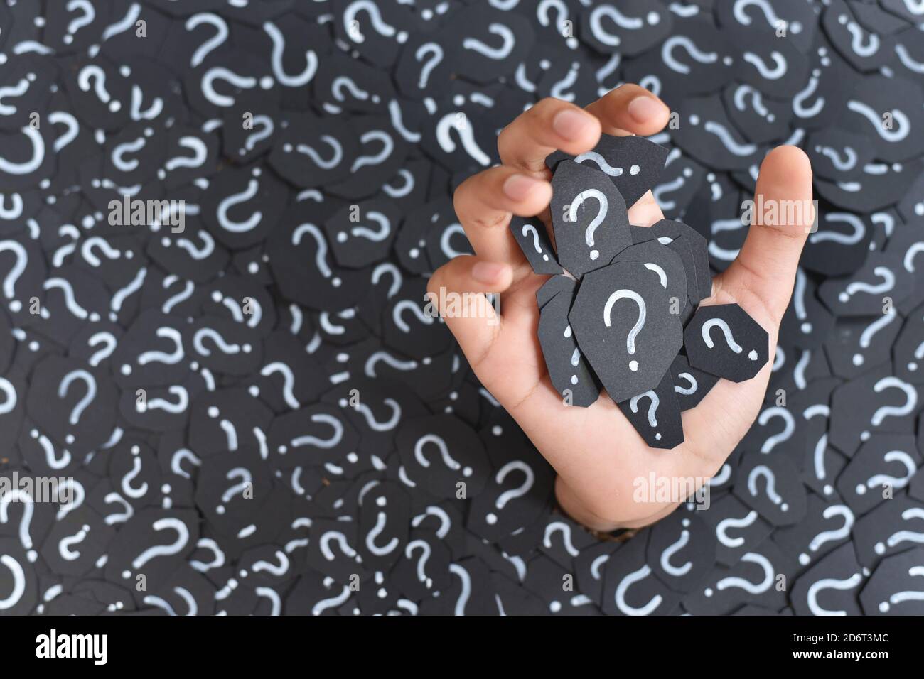 Main submergée de pile de papier avec point d'interrogation, concept de questions et réponses Banque D'Images