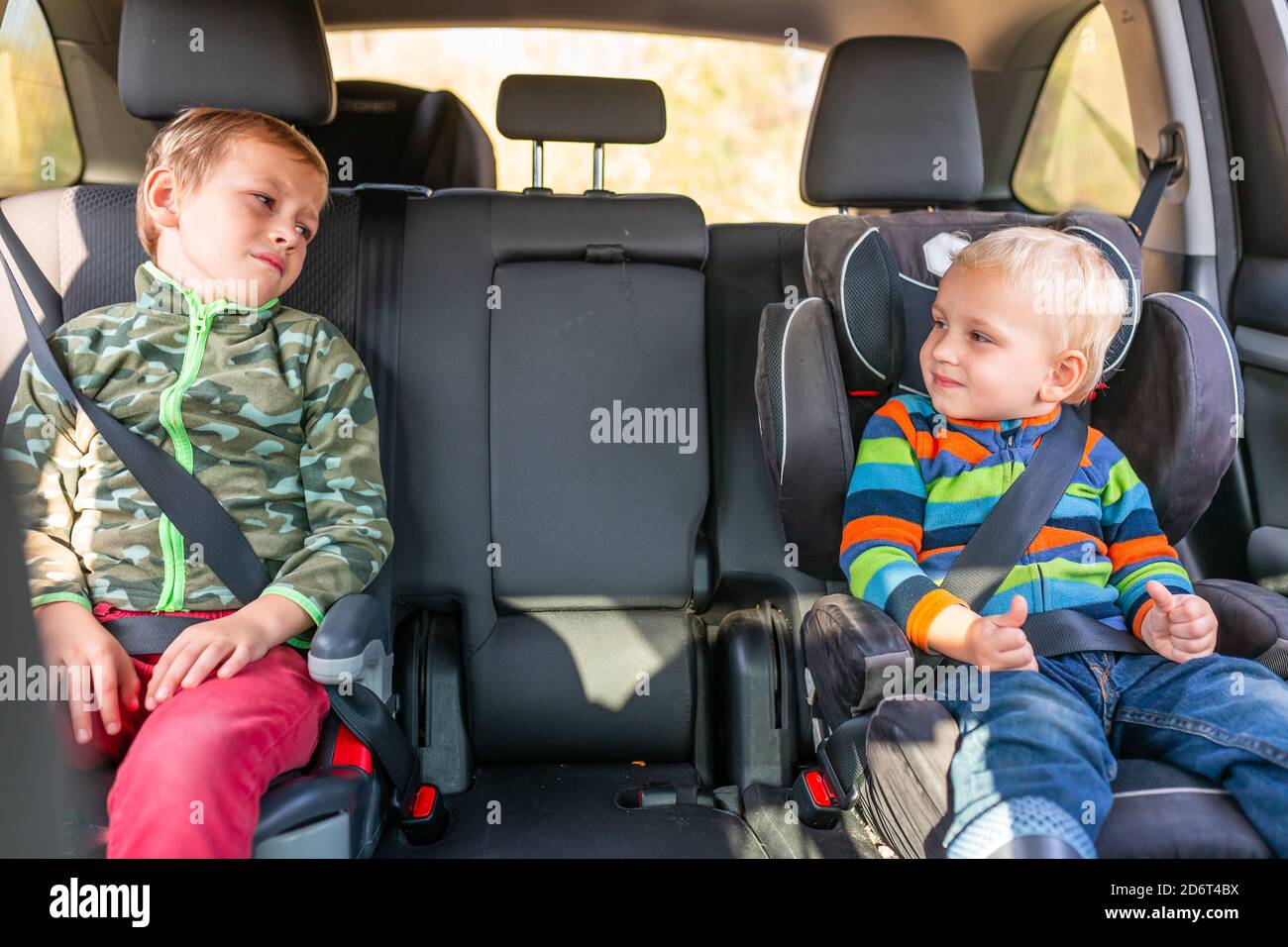 Deux petits garçons assis sur un siège d'auto et un rehausseur attaché dans  la voiture. Sécurité des sièges d'auto pour enfants Photo Stock - Alamy