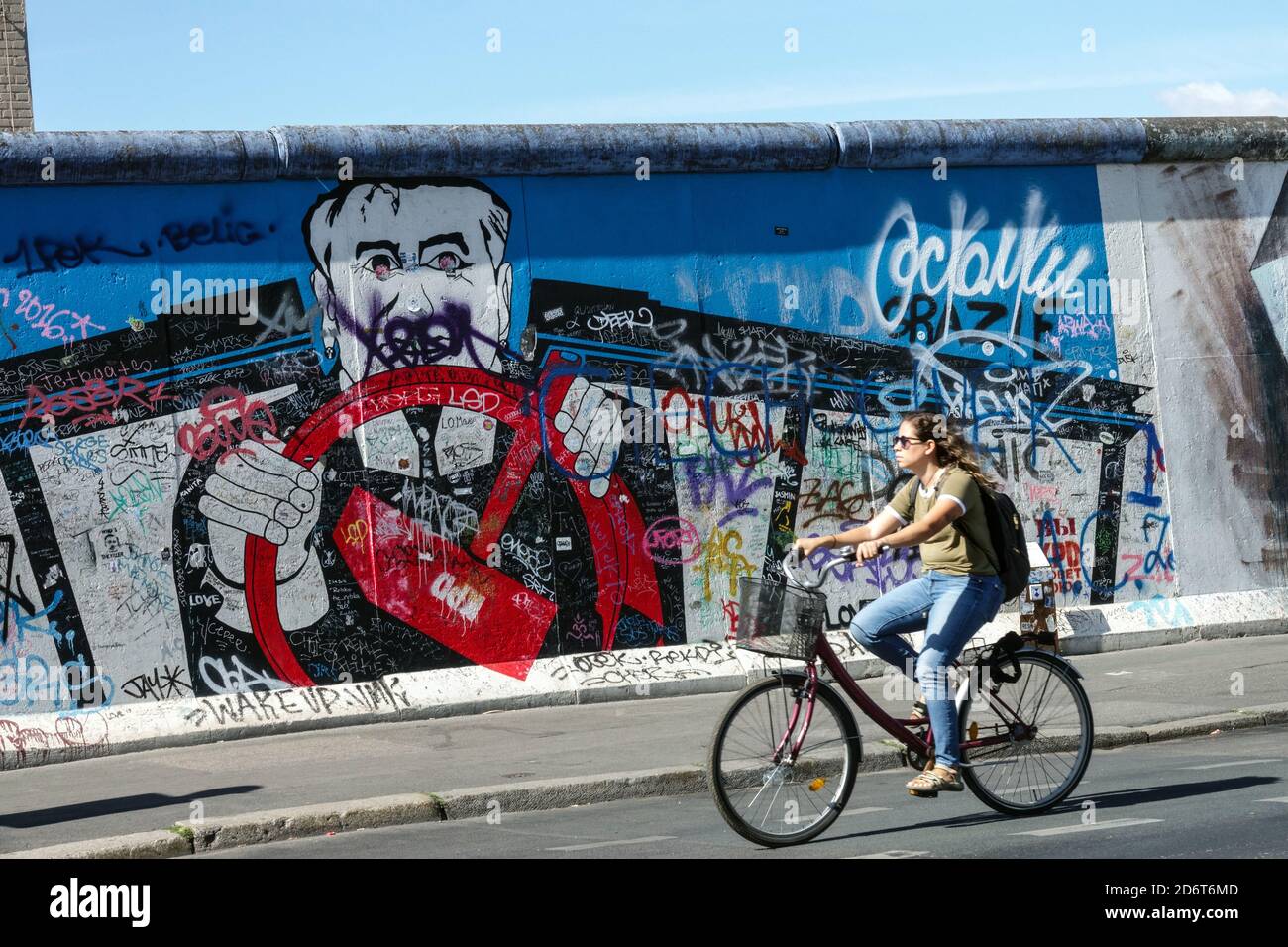 Femme à vélo mur de Berlin graffiti East Side Galerie Berlin Allemagne Friedrichshain ville rue art Europe ville vélo rue Berlin vélo mur Banque D'Images