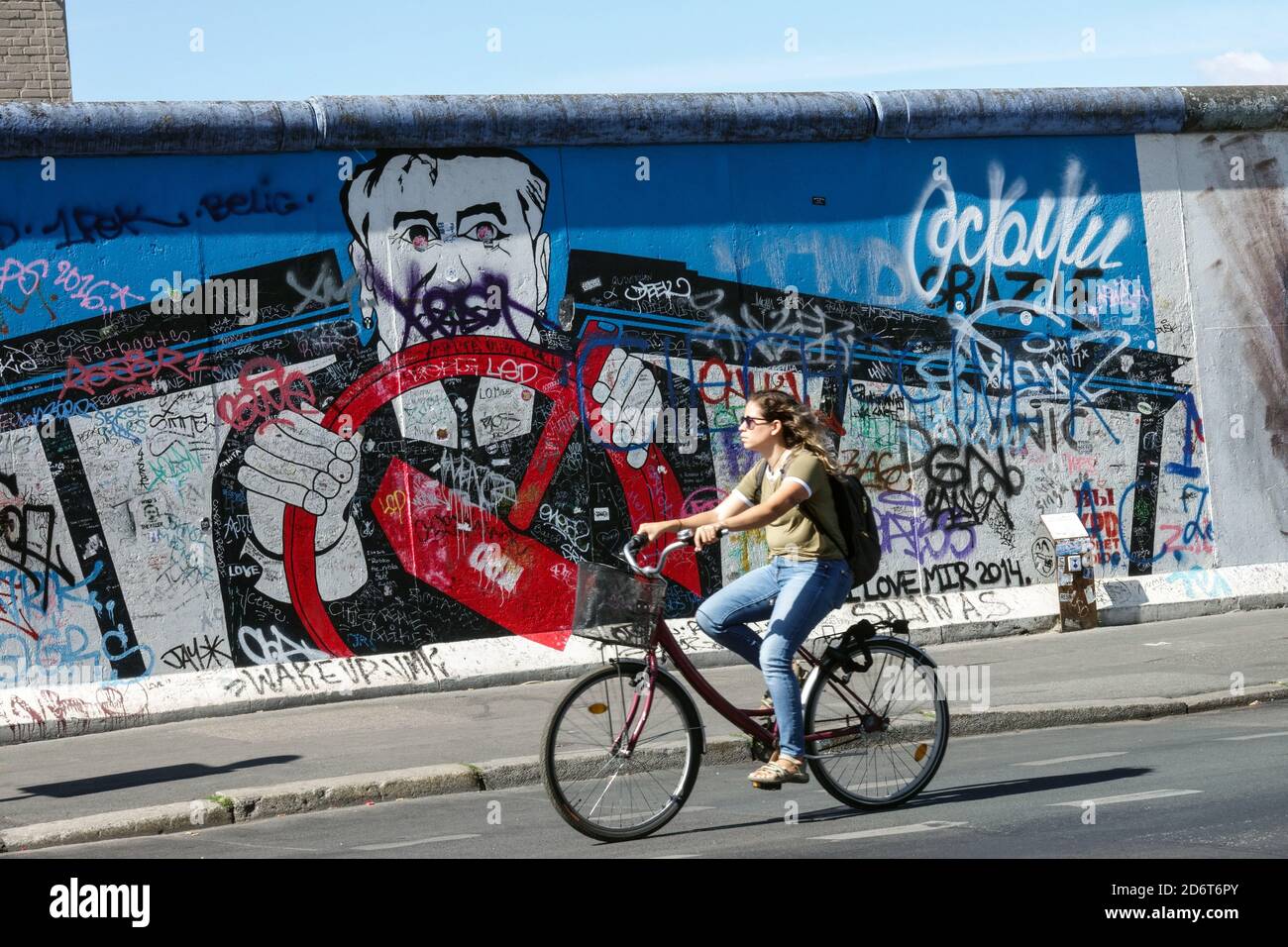 Berlin Wall graffiti East Side Gallery Berlin Street art femme monter un vélo Allemagne Friedrichshain City Street art Berlin vélo mur vélo seul Banque D'Images