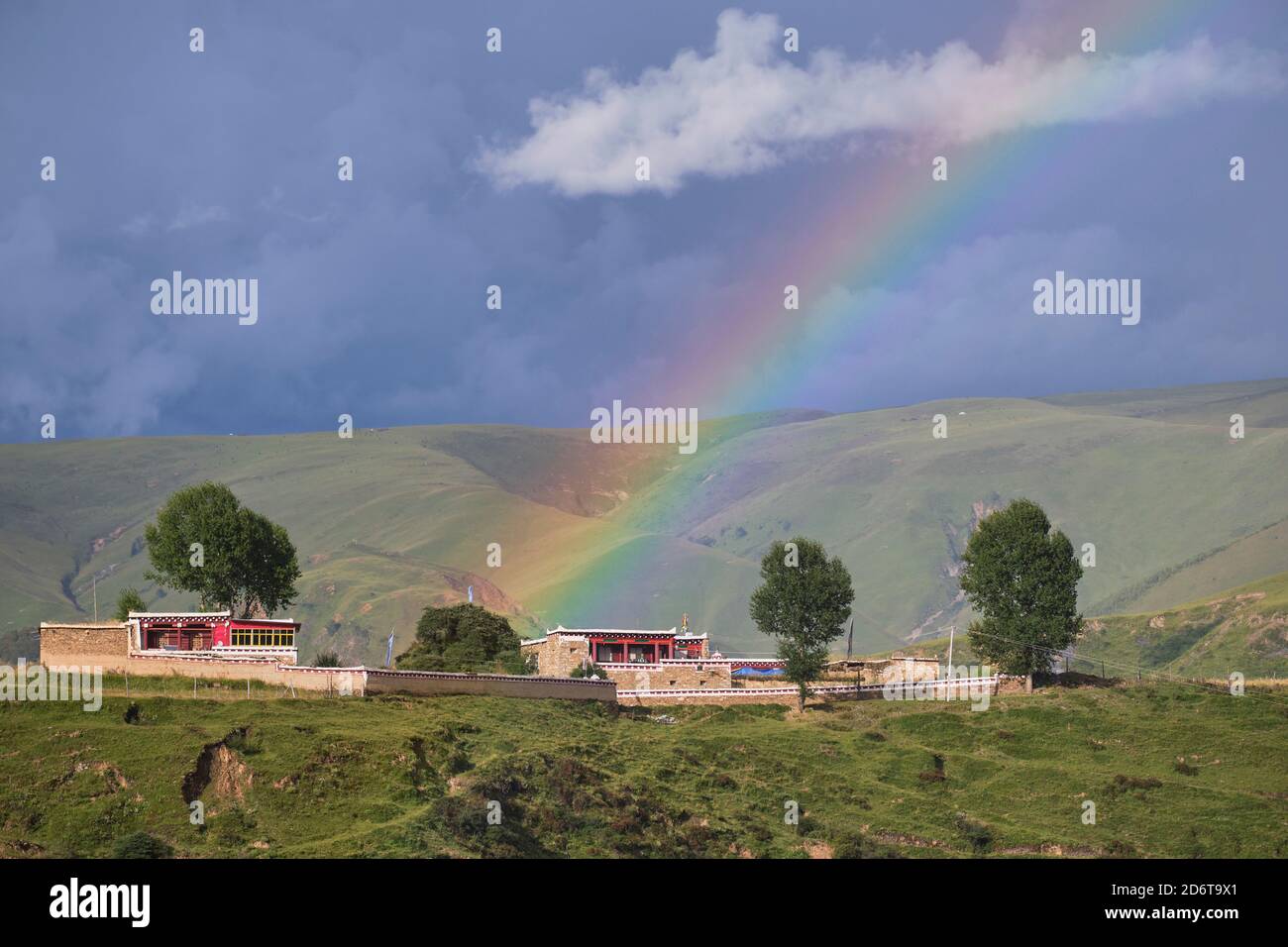 Paysage paisible de vallée verdoyante avec ferme sous la lumière ciel bleu avec nuages décolorés Banque D'Images