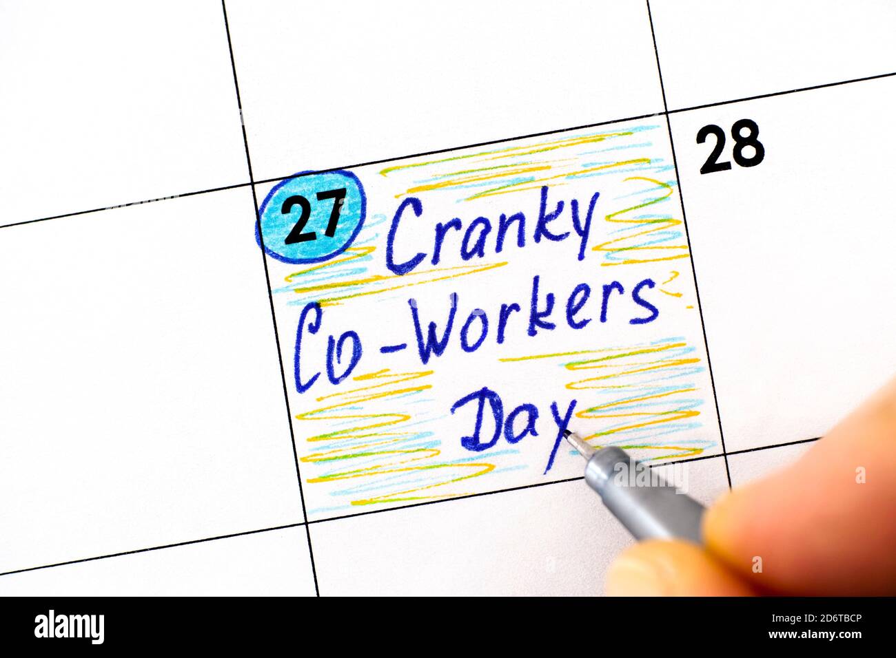 Femme doigts avec stylo écriture rappel Cranky Co-Workers Day dans le calendrier. Octobre 27 Banque D'Images