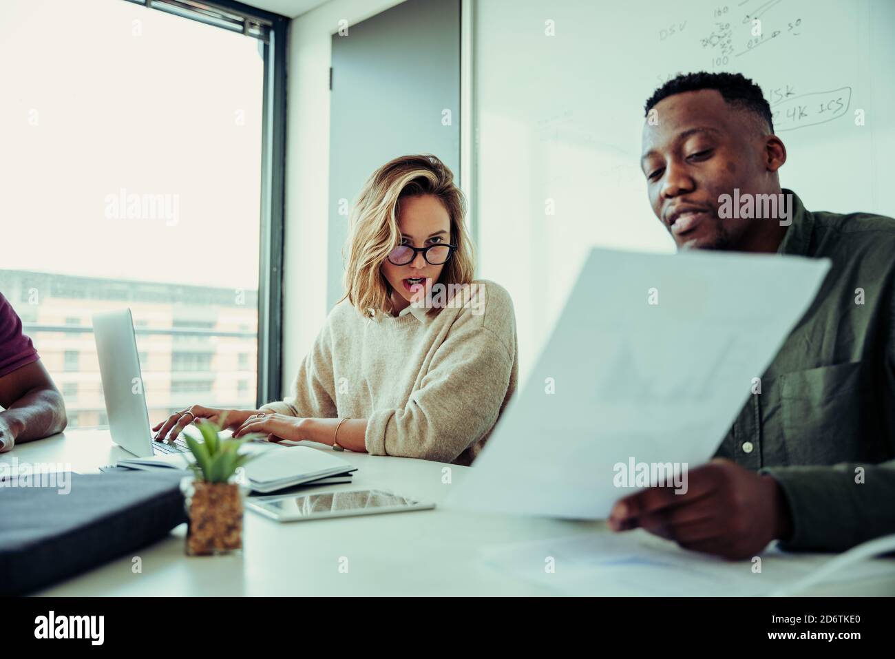 Une femme d'affaires a été choquée par les déclarations financières présentées par un homme d'affaires assis lors d'une réunion dans la salle de réunion. Banque D'Images