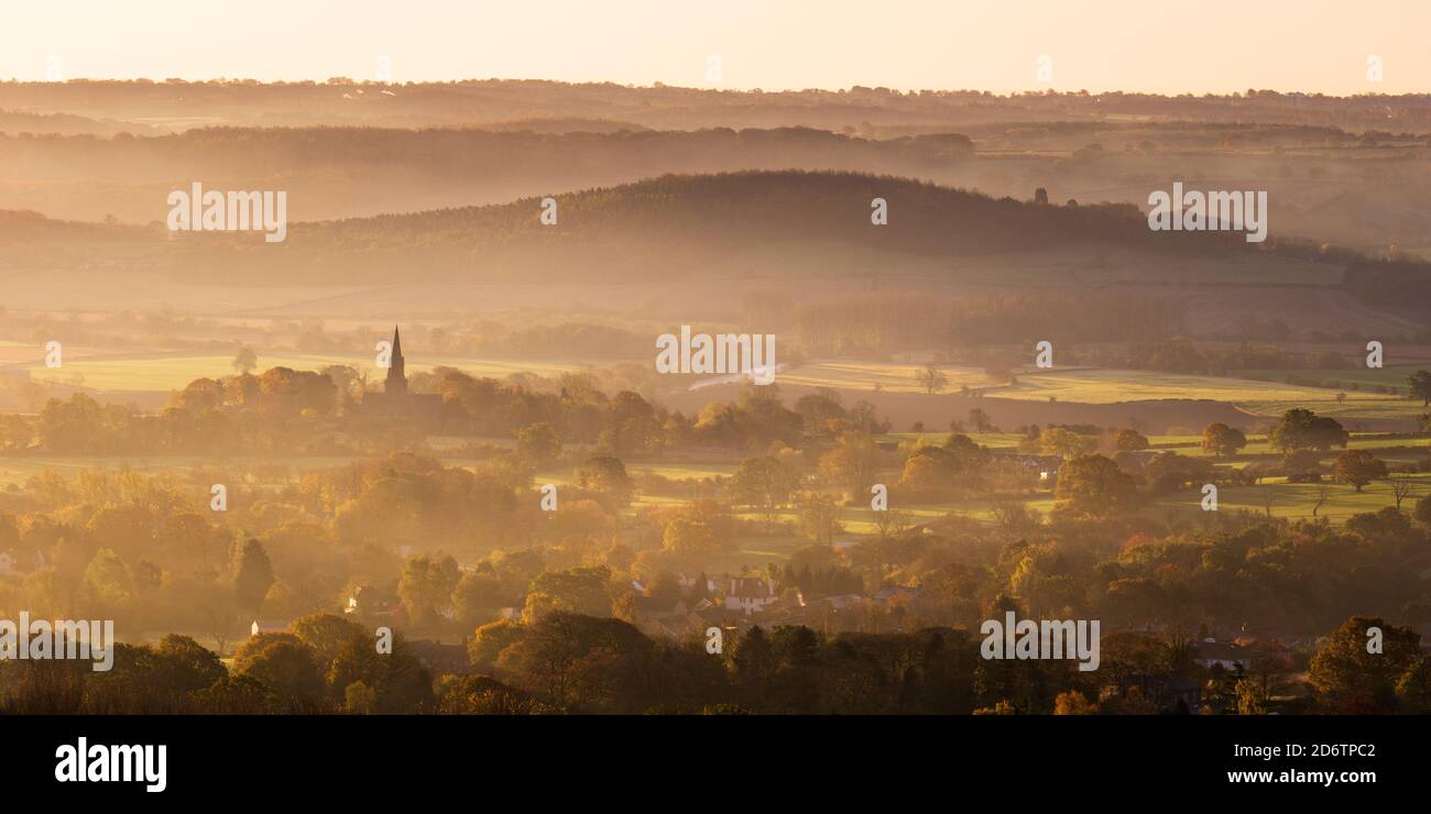 Une belle lumière dorée met en lumière la riche couleur qui entoure le village de Weeton et les pâturages d'Arthington lors d'une matinée d'automne brumeuse. Banque D'Images