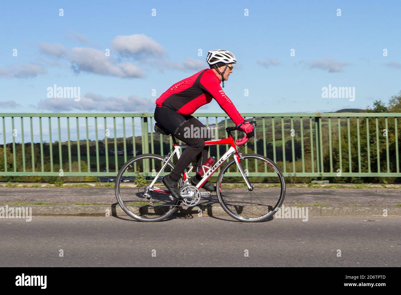 Cycliste de race Trek en fibre de carbone léger vélo de route sur la route de campagne traversant le pont d'autoroute dans la campagne du Lancashire, Royaume-Uni Banque D'Images