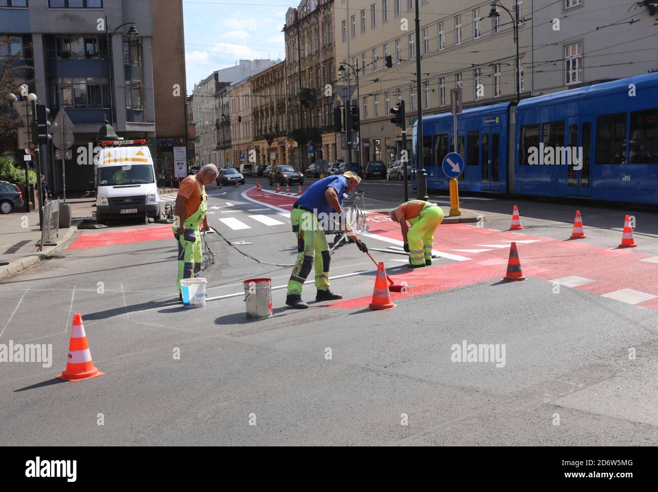 Cracovie. Cracovie. Pologne. Les travailleurs peignant des panneaux de signalisation routière horizontaux sur la route. Banque D'Images