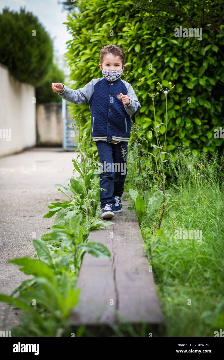 Enfant portant un masque en tissu, France. Banque D'Images