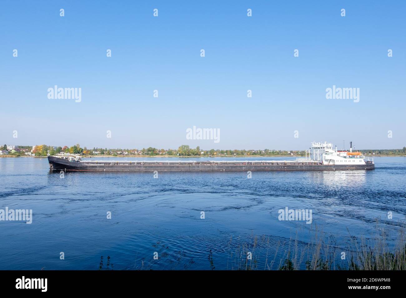 Un navire de cargaison sèche commercial navigue le long de la rivière en été ou au début de l'automne. Orientation horizontale, mise au point sélective. Banque D'Images