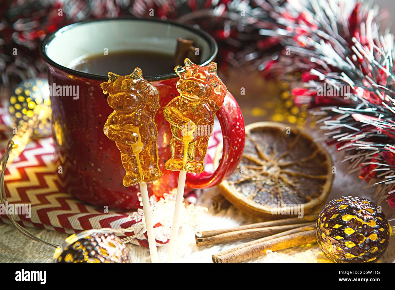 Deux sucettes sur bâton en forme de symbole nouvel an 2021 - taureau sur le fond décor de Noël avec une tasse de thé rouge. Guirlande, cannelle et séché o Banque D'Images