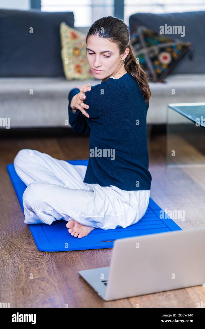 Femme pratiquant le yoga en ligne sur ordinateur portable à la maison. Banque D'Images