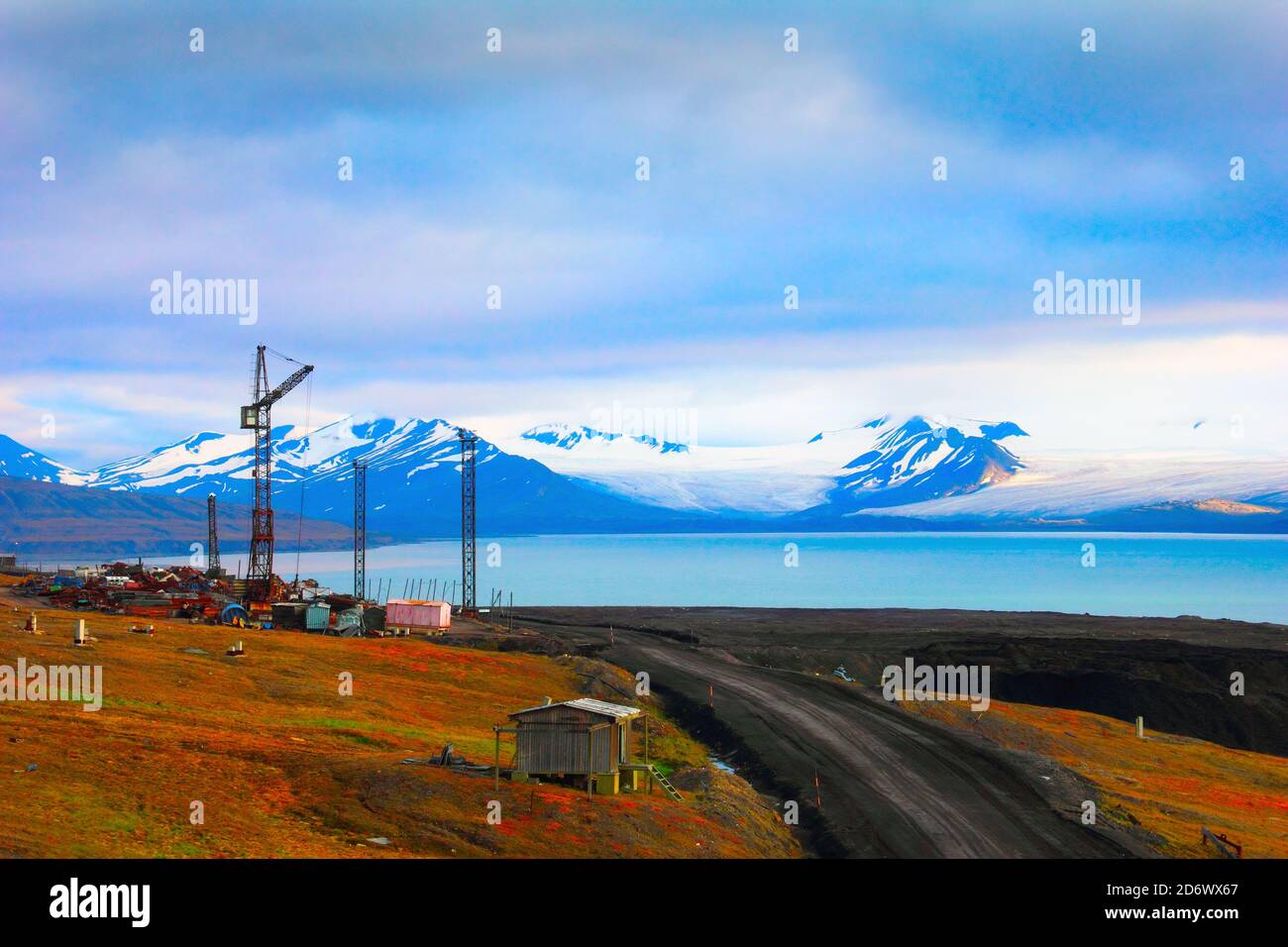 Belle vue panoramique du golfe bleu sous les montagnes arides avec la fonte de la neige, route du désert et pont-grue abandonné près de Barentsburg, Spitsbergen (Svalb Banque D'Images