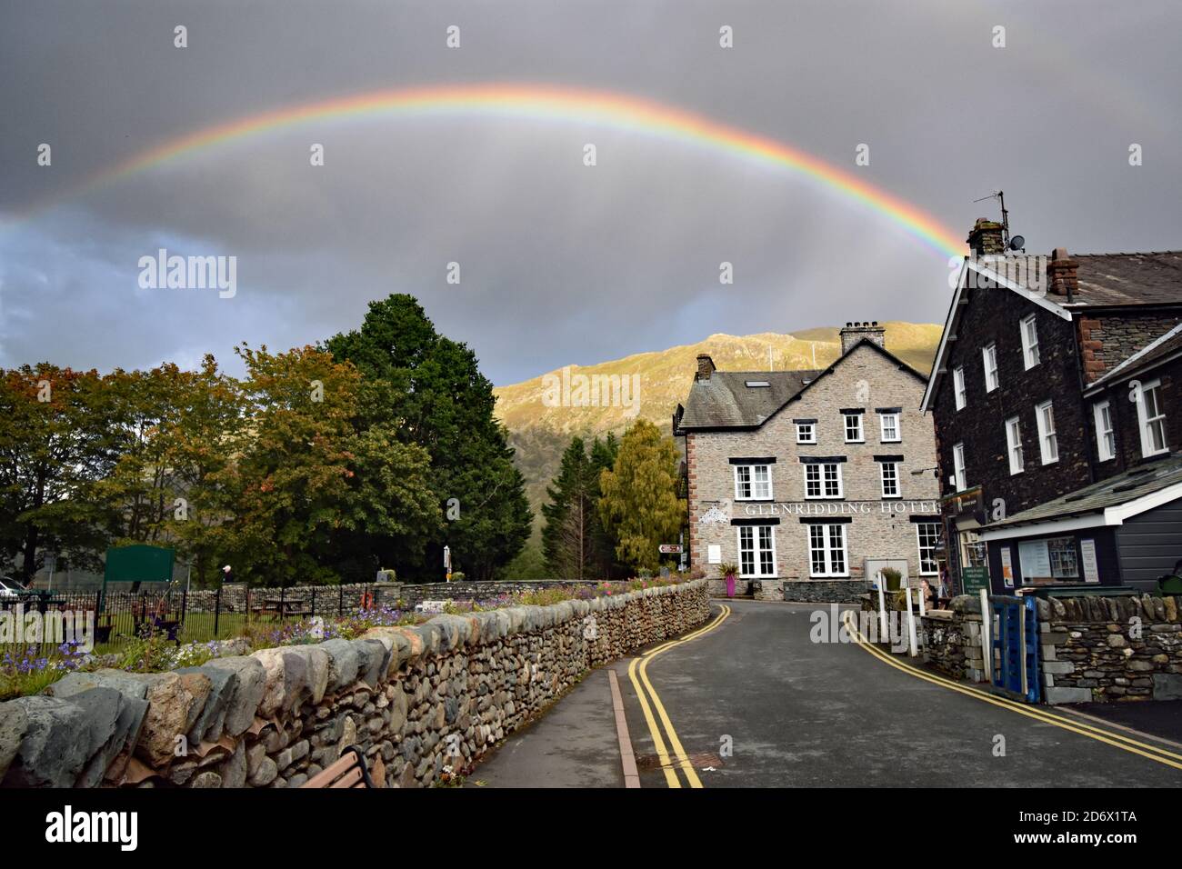 Un arc-en-ciel au-dessus de l'hôtel Glenridding, à la limite d'Ullswater, dans le parc national du Lake District. Un mur en pierre mène à l'hôtel. Banque D'Images