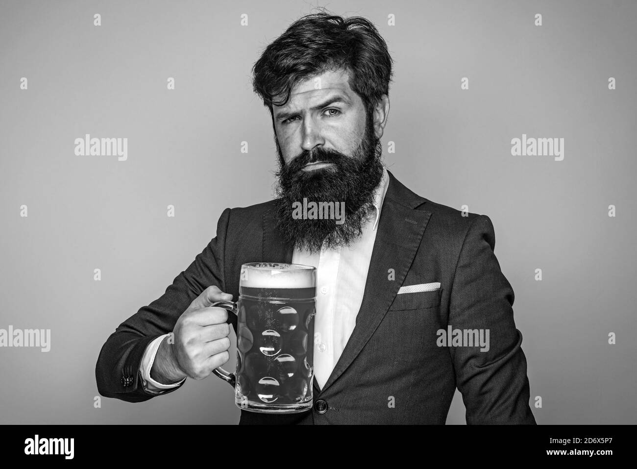 Homme en costume noir buvant de la bière. Homme avec de la bière. Homme avec la barbe boire de la bière. Homme rétro avec une bière. Profitez au pub. Banque D'Images