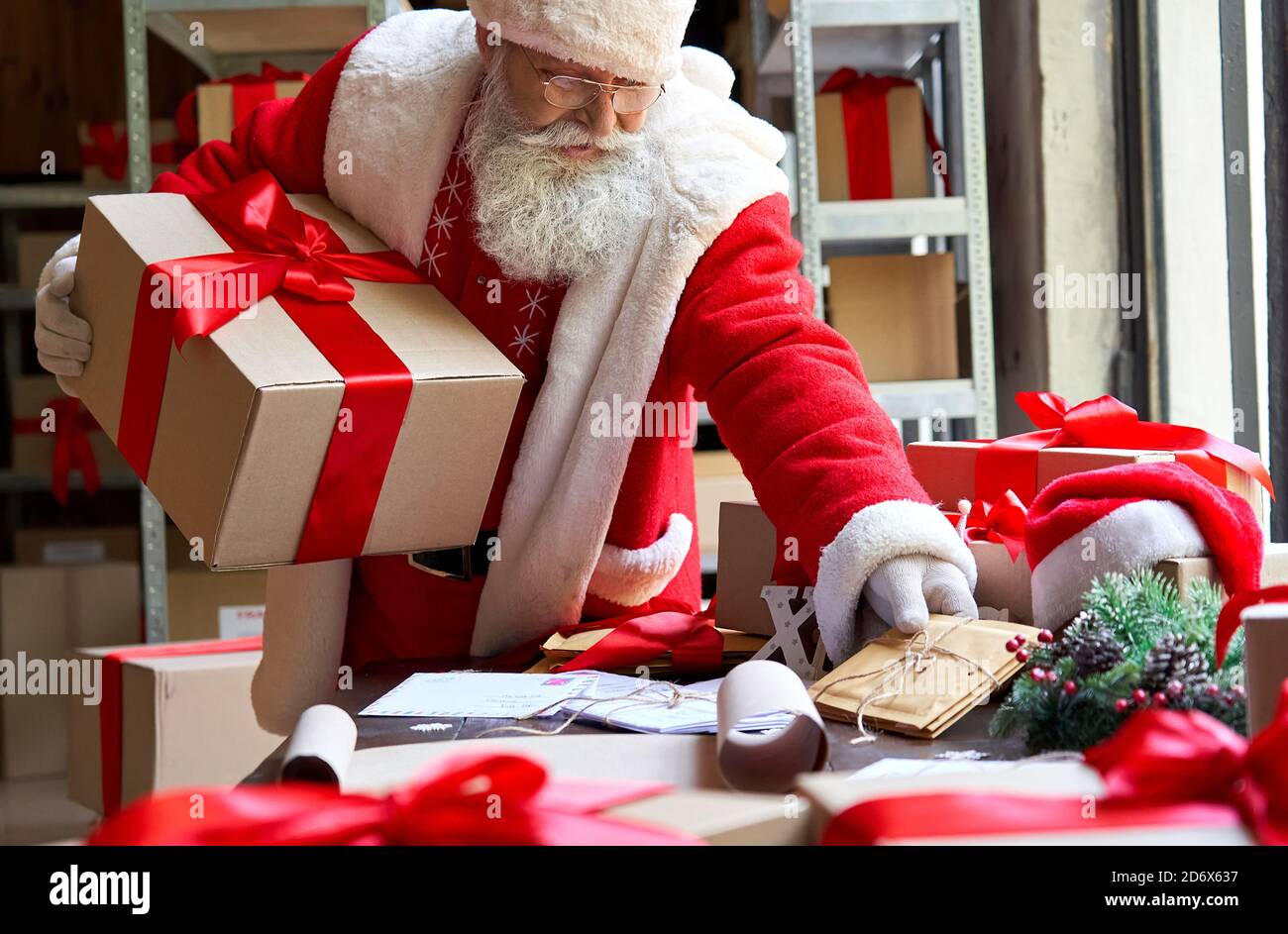 Le Père Noël tient le cadeau boîte cadeaux préparation pour Noël en atelier  Photo Stock - Alamy