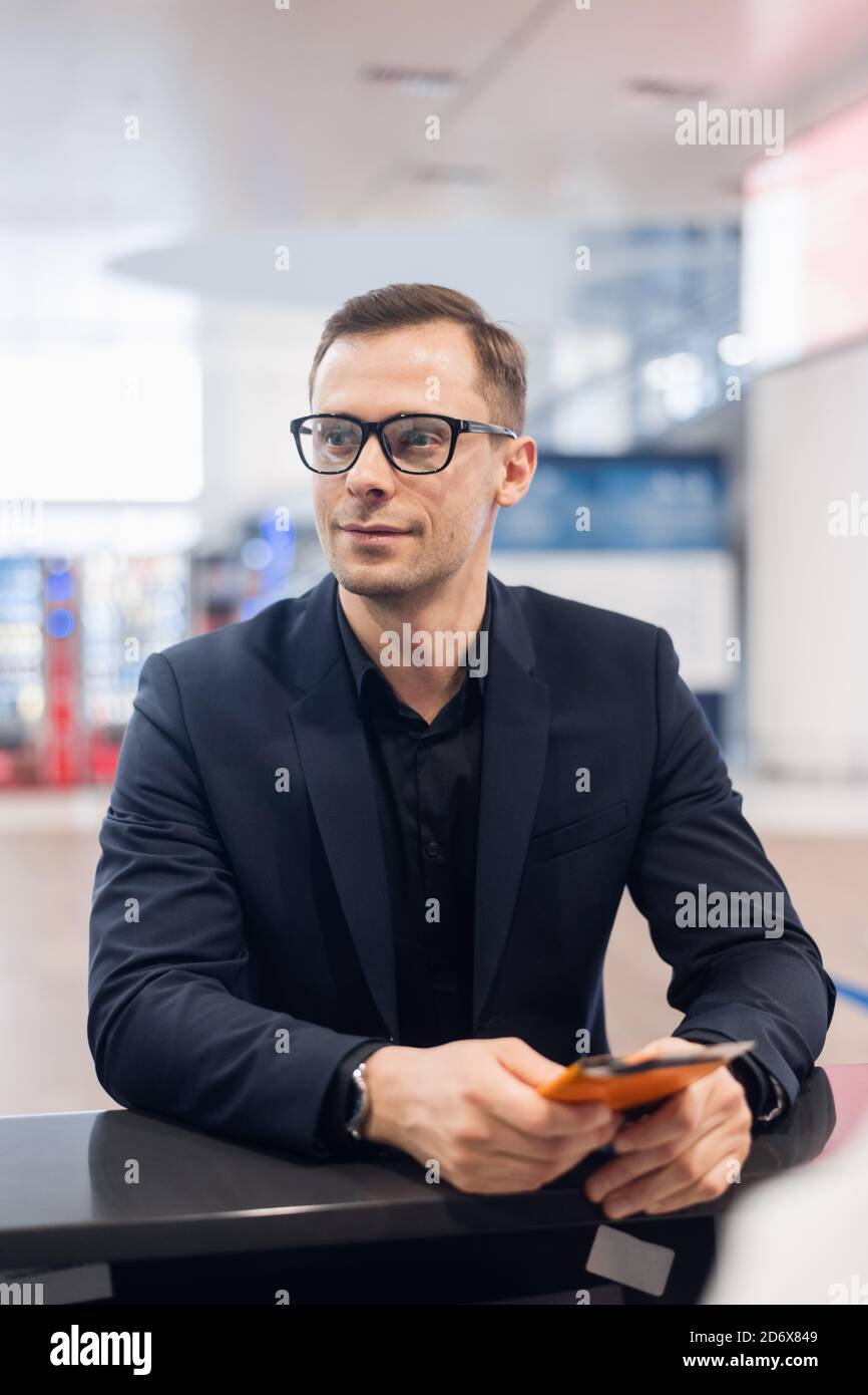 Handsome businessman handing over air billet au comptoir de compagnie aérienne Banque D'Images