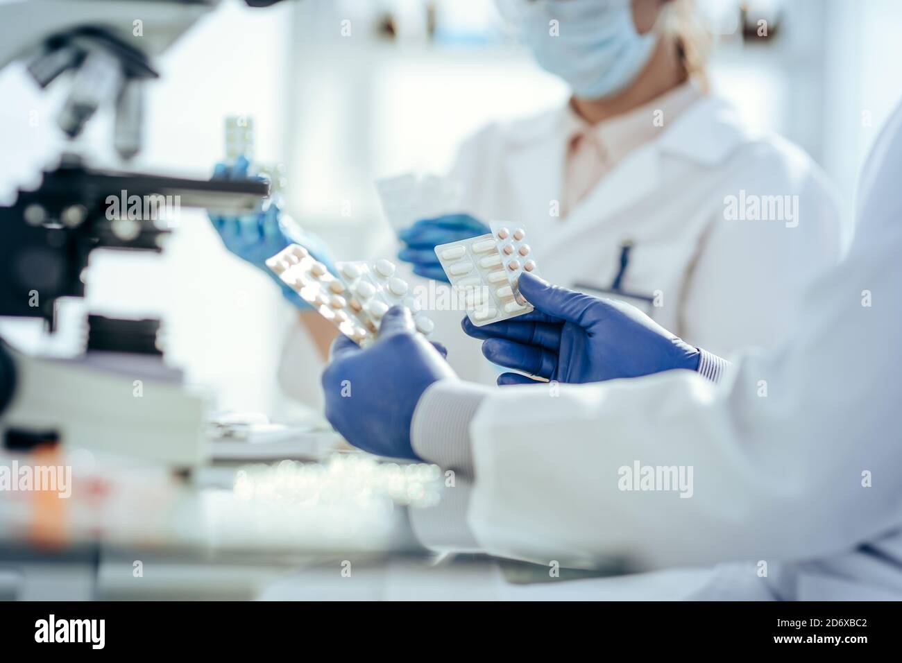 scientifiques avec des échantillons de nouveaux médicaments assis à une table de laboratoire. Banque D'Images