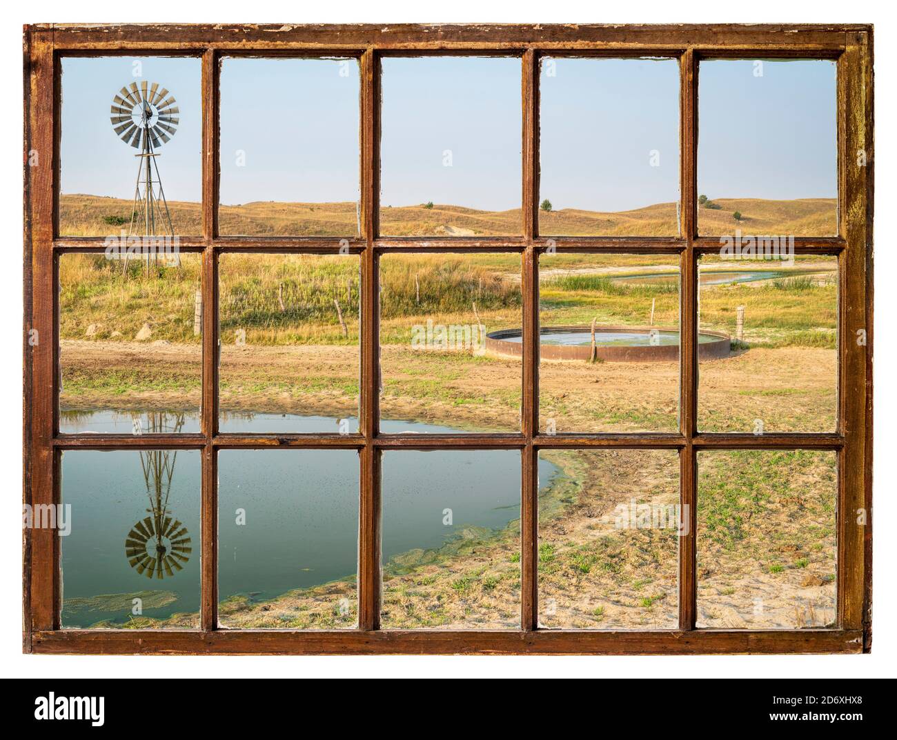 Trou de boisson de bétail dans une prairie de Nebraska Sandhills - paysage d'automne le matin vu d'une fenêtre à guillotine vintage Banque D'Images