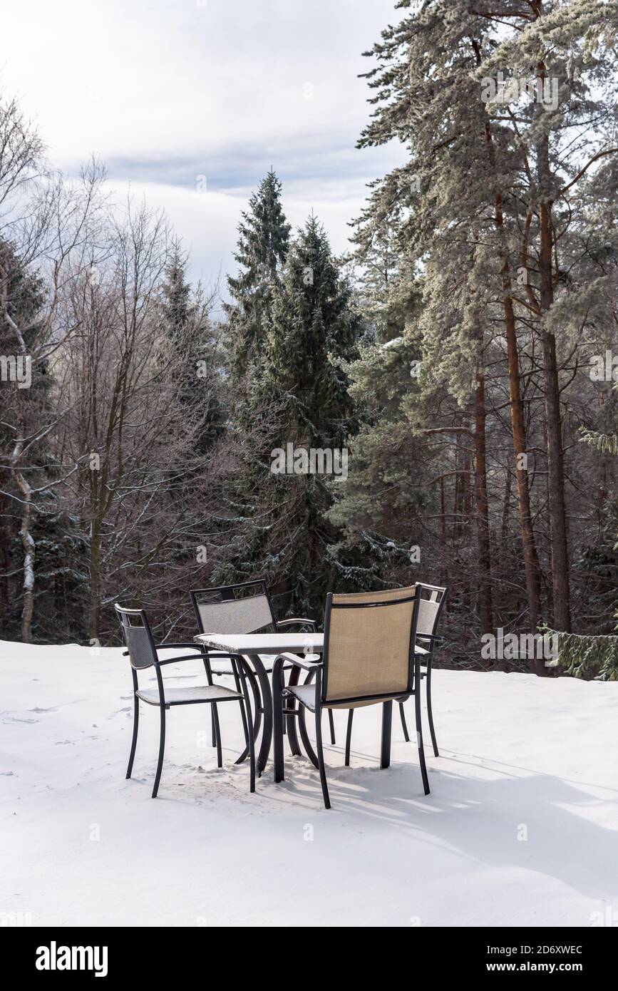 Table de restaurant vide et chaises sur une neige dans les montagnes Beski Sadecki, Krynica Zdroj, Pologne Banque D'Images