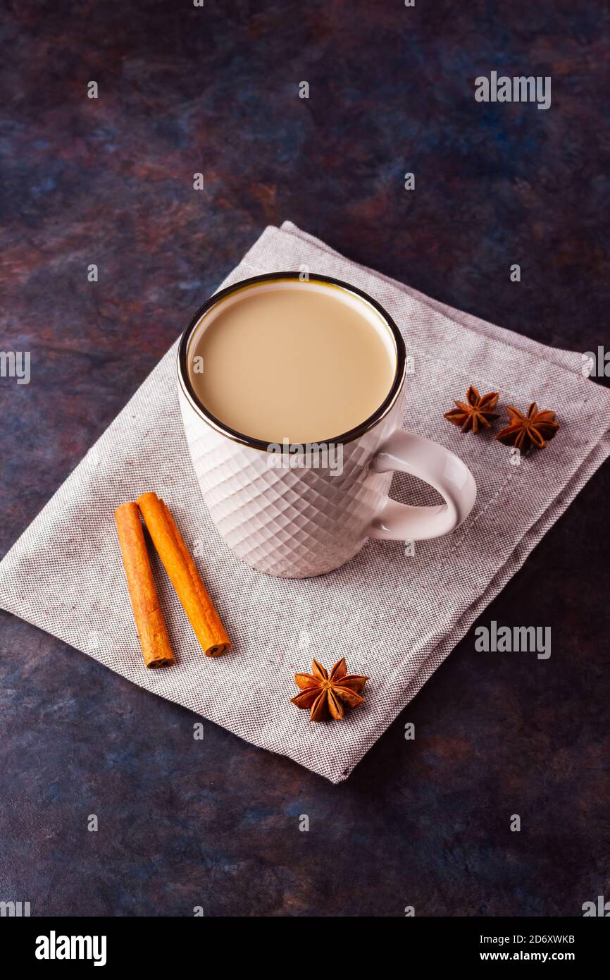 Thé Chai de masala. Boisson traditionnelle indienne - thé masala avec épices sur fond noir. Tasse en céramique d'épices thé sur serviette en lin Banque D'Images