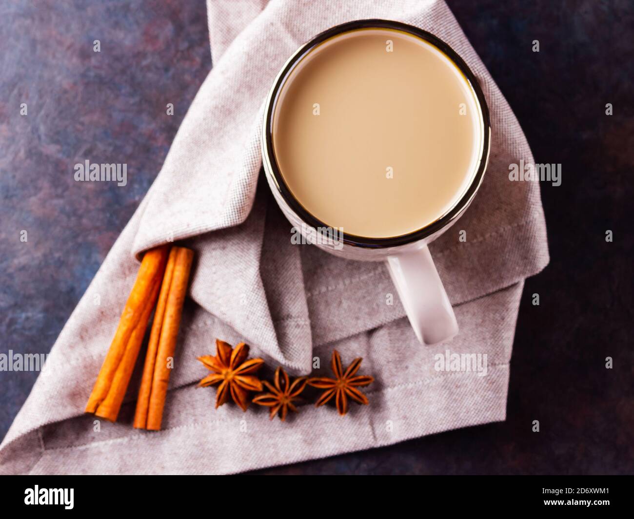 Thé Chai de masala. Boisson traditionnelle indienne - thé masala avec épices sur fond noir. Tasse en céramique d'épices thé sur serviette en lin Banque D'Images