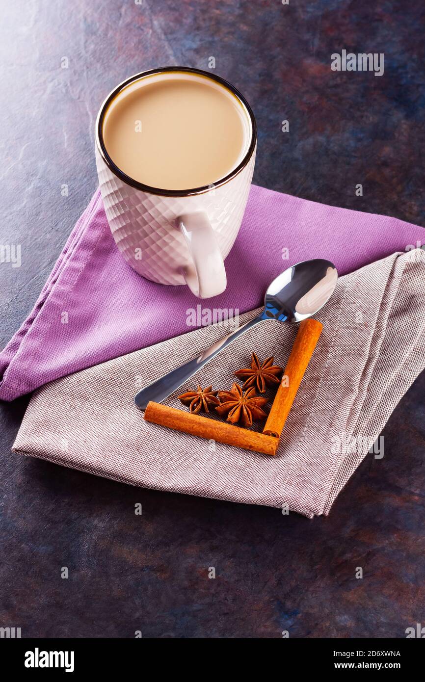 Thé Chai de masala. Boisson traditionnelle indienne - thé masala avec épices sur fond noir. Tasse en céramique d'épices thé sur serviette en lin Banque D'Images