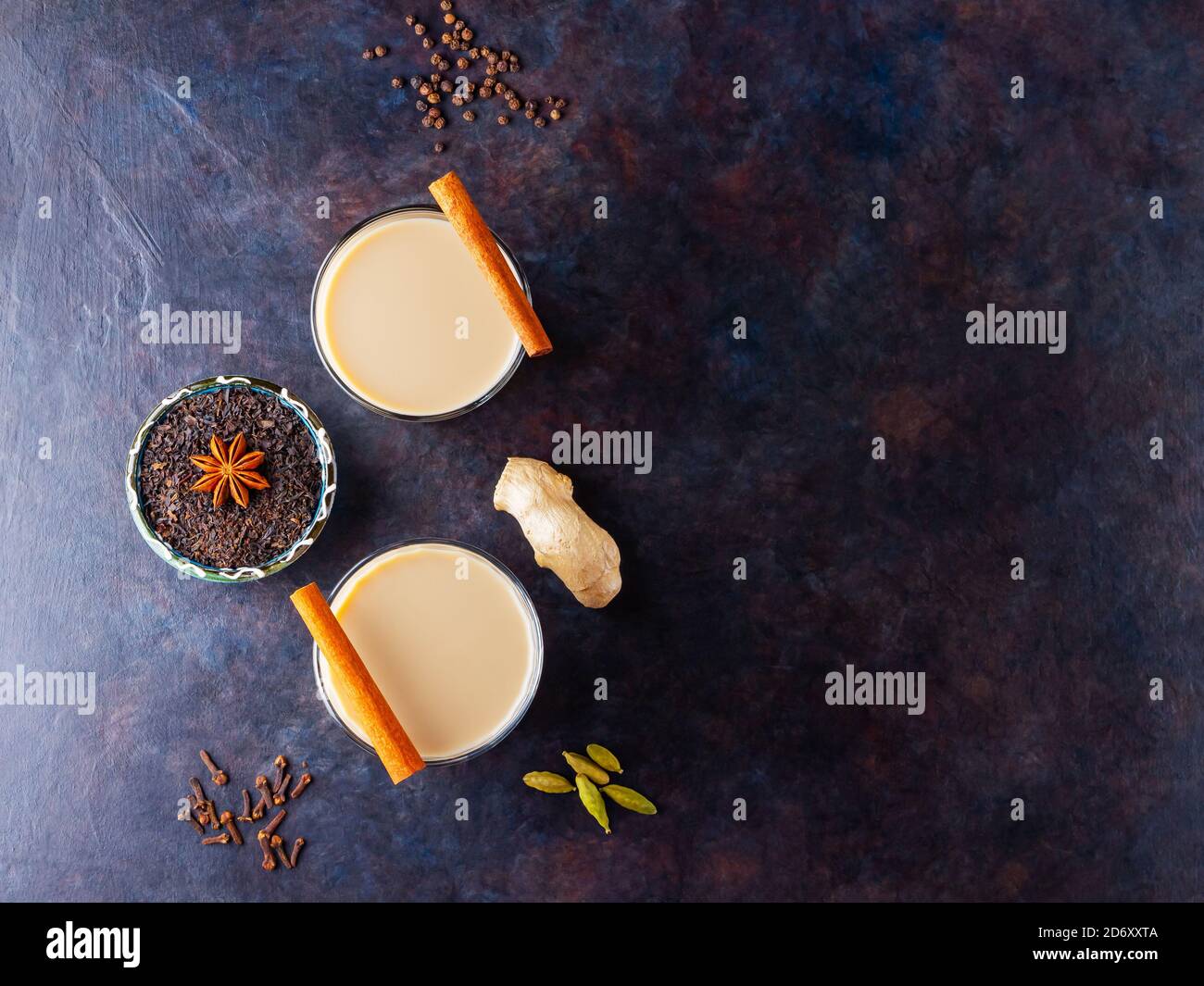 Thé Chai de masala. Boisson traditionnelle indienne - thé masala avec diverses épices. Deux verres avec thé masala sur fond sombre Banque D'Images