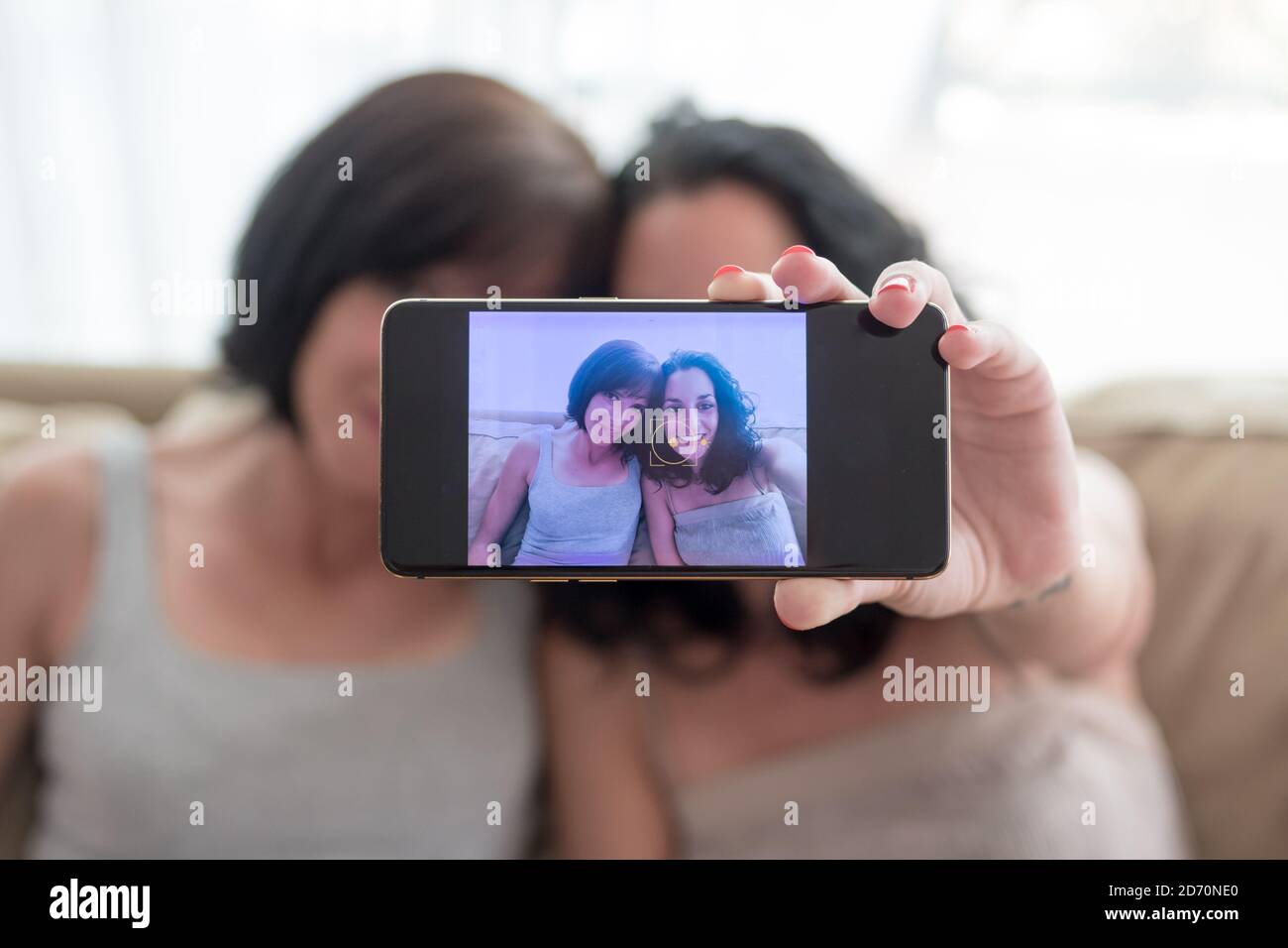 deux jeunes femmes s'amusent et rient en prenant un selfie avec leurs téléphones Banque D'Images