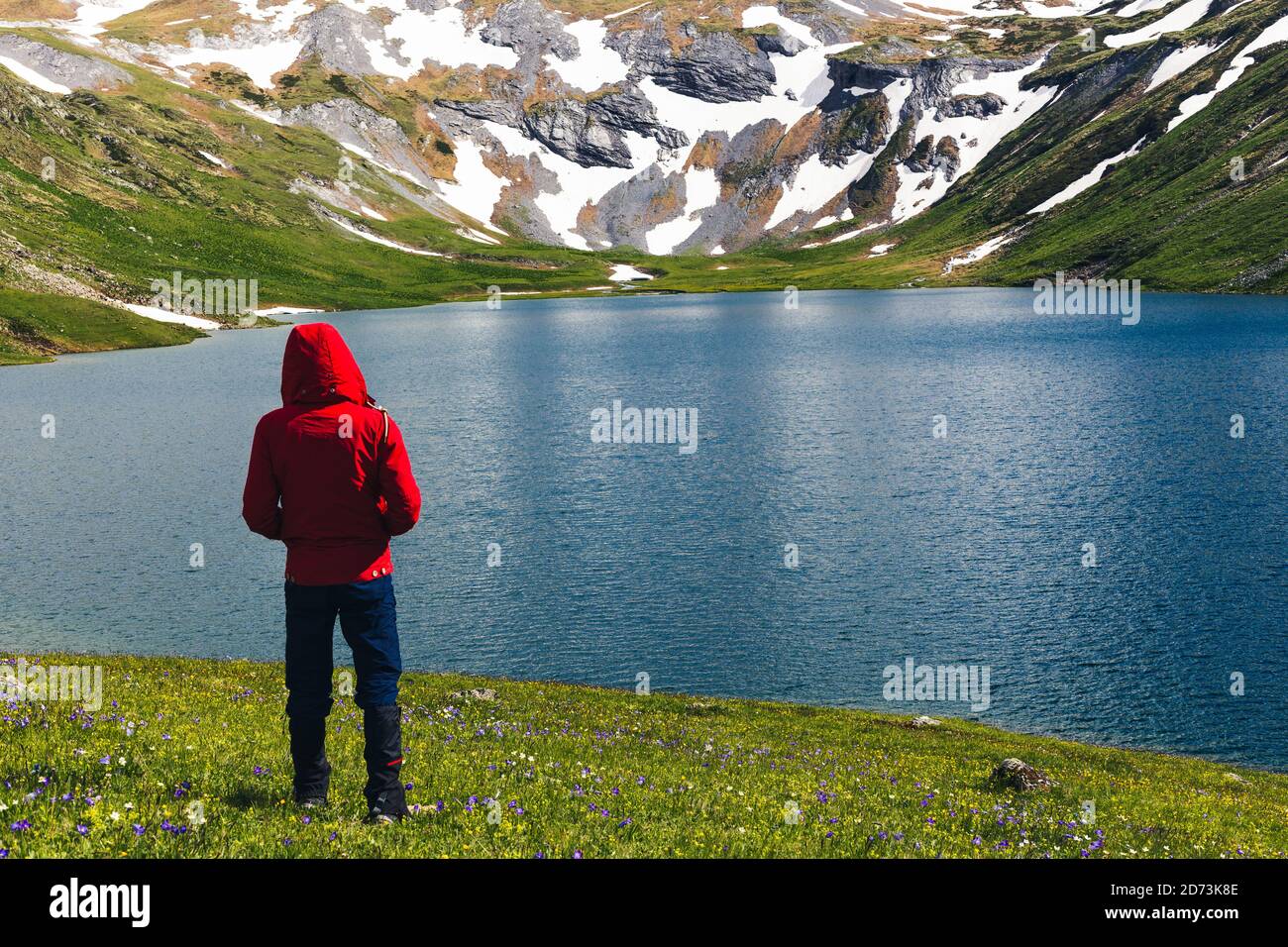 Le randonneur à lui seul bénéficie du lever du soleil dans les hautes montagnes surplombant le lac. Voyage vacances actif sain style de vie aventure voyage en plein air Banque D'Images