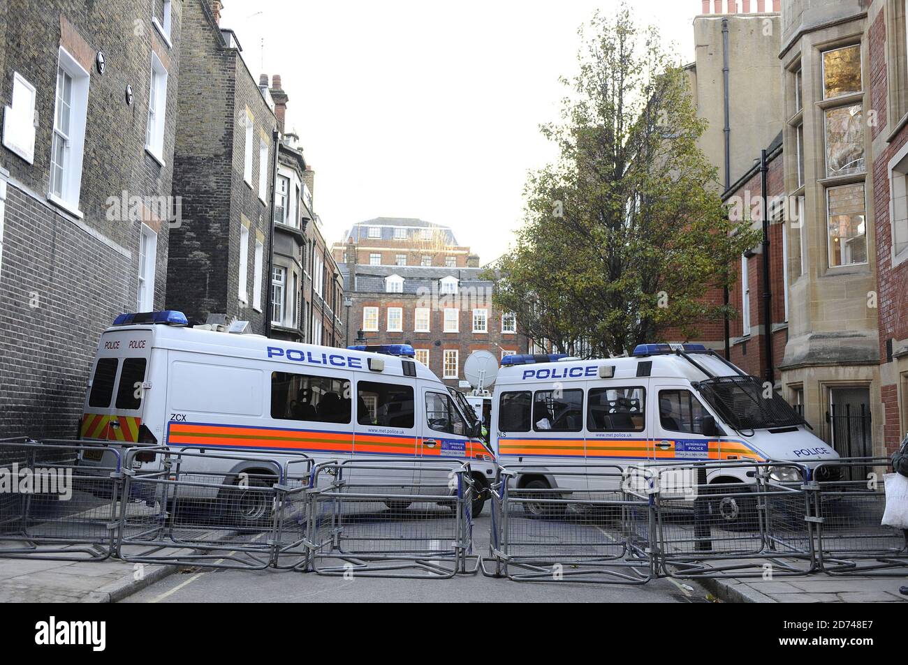 Le quartier général libéral démocrate de Barton Street, dans le centre de Londres, est protégé par la police, tandis que les manifestants manifestent lors d'un débat sur la proposition d'augmentation des frais de scolarité universitaires. Banque D'Images