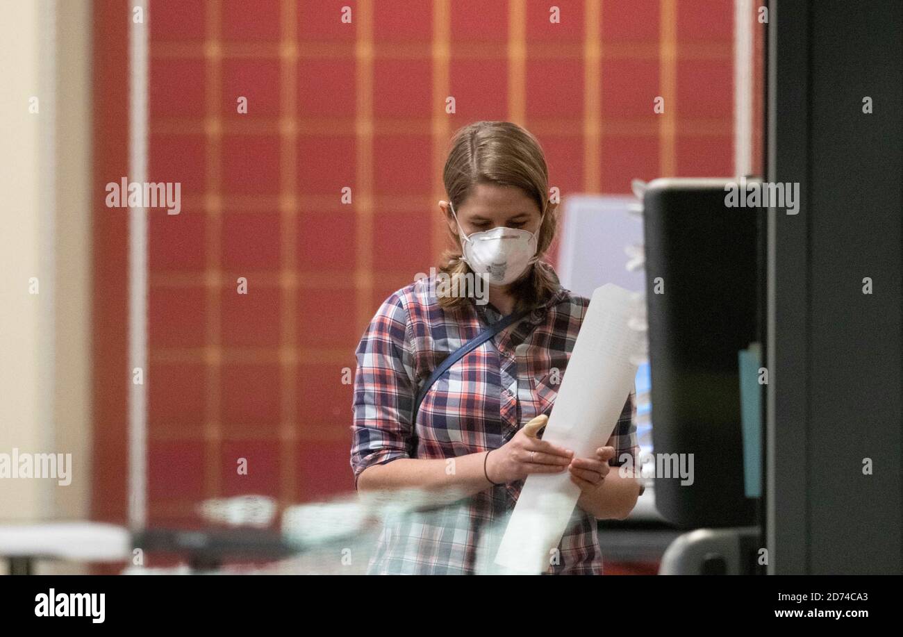 Austin, Texas le 20 octobre 2020 : un électeur masqué du comté de Travis passe en revue son bulletin de vote sur papier, généré par la machine électronique sur laquelle elle a voté à un bureau de vote par anticipation dans le nord d'Austin. Le bulletin de vote est exécuté par un scanner, puis stocké sous forme de copie papier de sauvegarde. Crédit : Bob Daemmrich/Alay Live News Banque D'Images