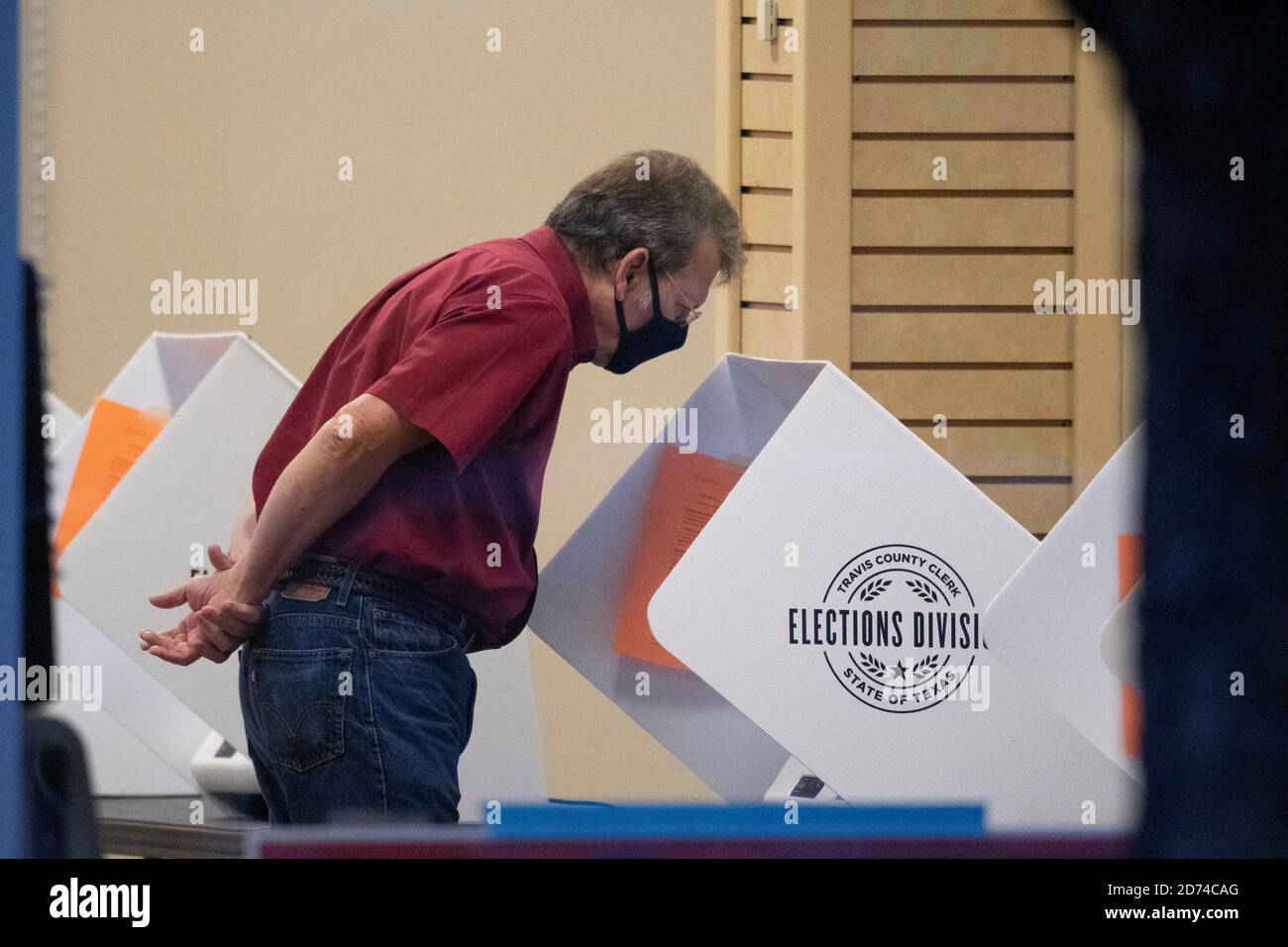 Austin, Texas le 20 octobre 2020: L'électeur Terry Welch, le comte de Travis masqué, regarde un bulletin de vote sur un système de vote électronique pendant la période de vote précoce au Texas. Le comté a atteint en moyenne un record de 35,000 électeurs par jour et il reste deux semaines avant les élections du 3 novembre. Les Texans ont voté plus de quatre millions de bulletins de vote jusqu'à présent. Crédit : Bob Daemmrich/Alay Live News Banque D'Images