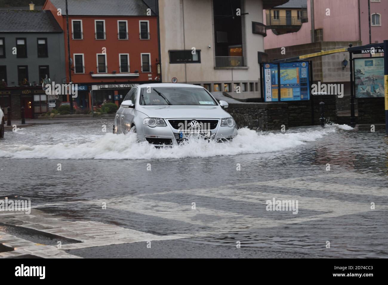 Voiture traversant les eaux inondées de Wolfe Tone Square. Bantry, Co Cork. Irlande. Banque D'Images