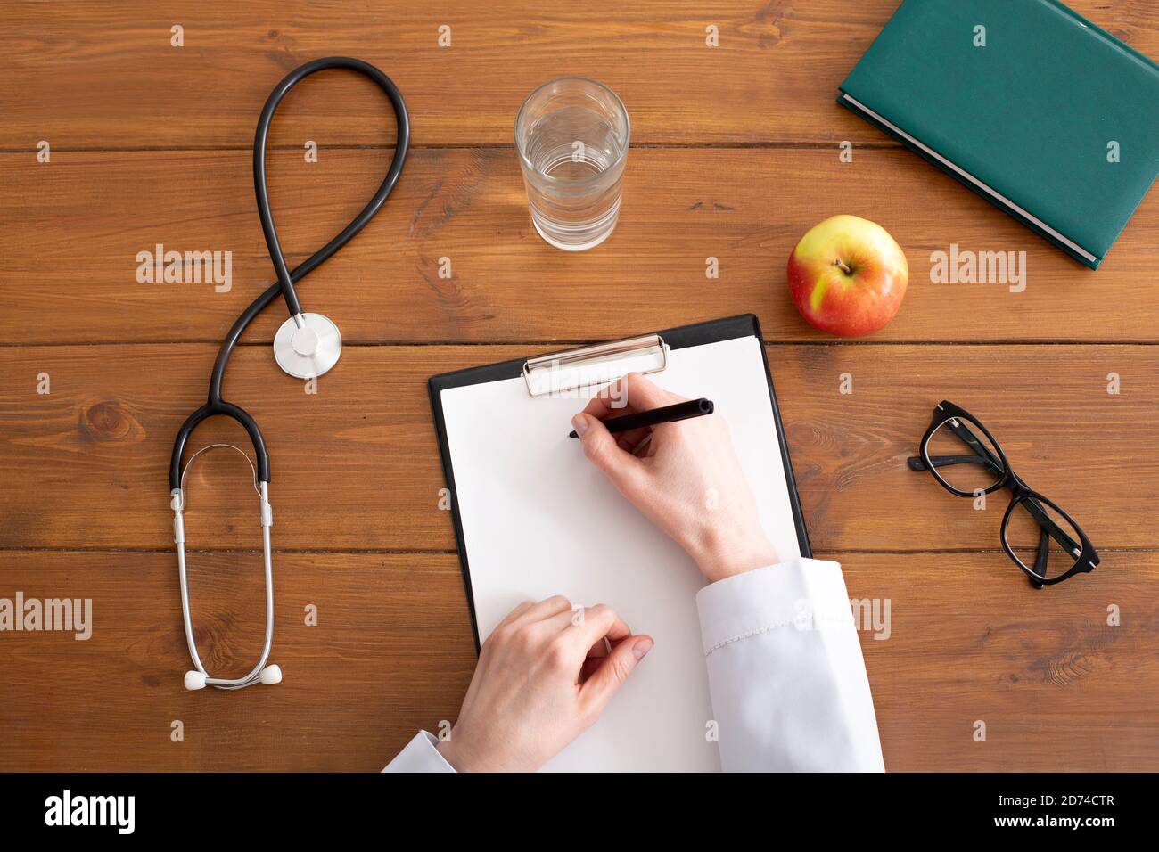 Recommandations et prescription du médecin. Femme en manteau blanc écrit sur une tablette sur le lieu de travail Banque D'Images