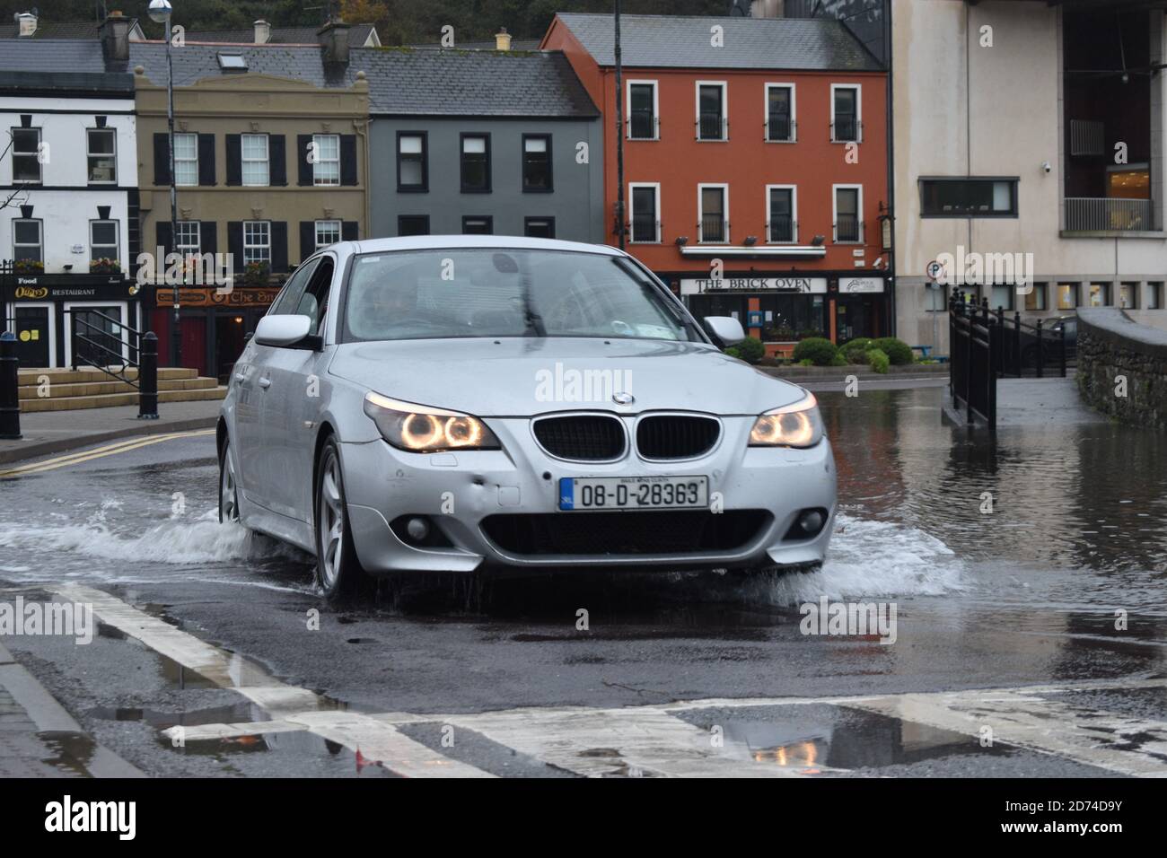 Voiture traversant les eaux inondées de Wolfe Tone Square. Bantry, Co Cork. Irlande. Banque D'Images