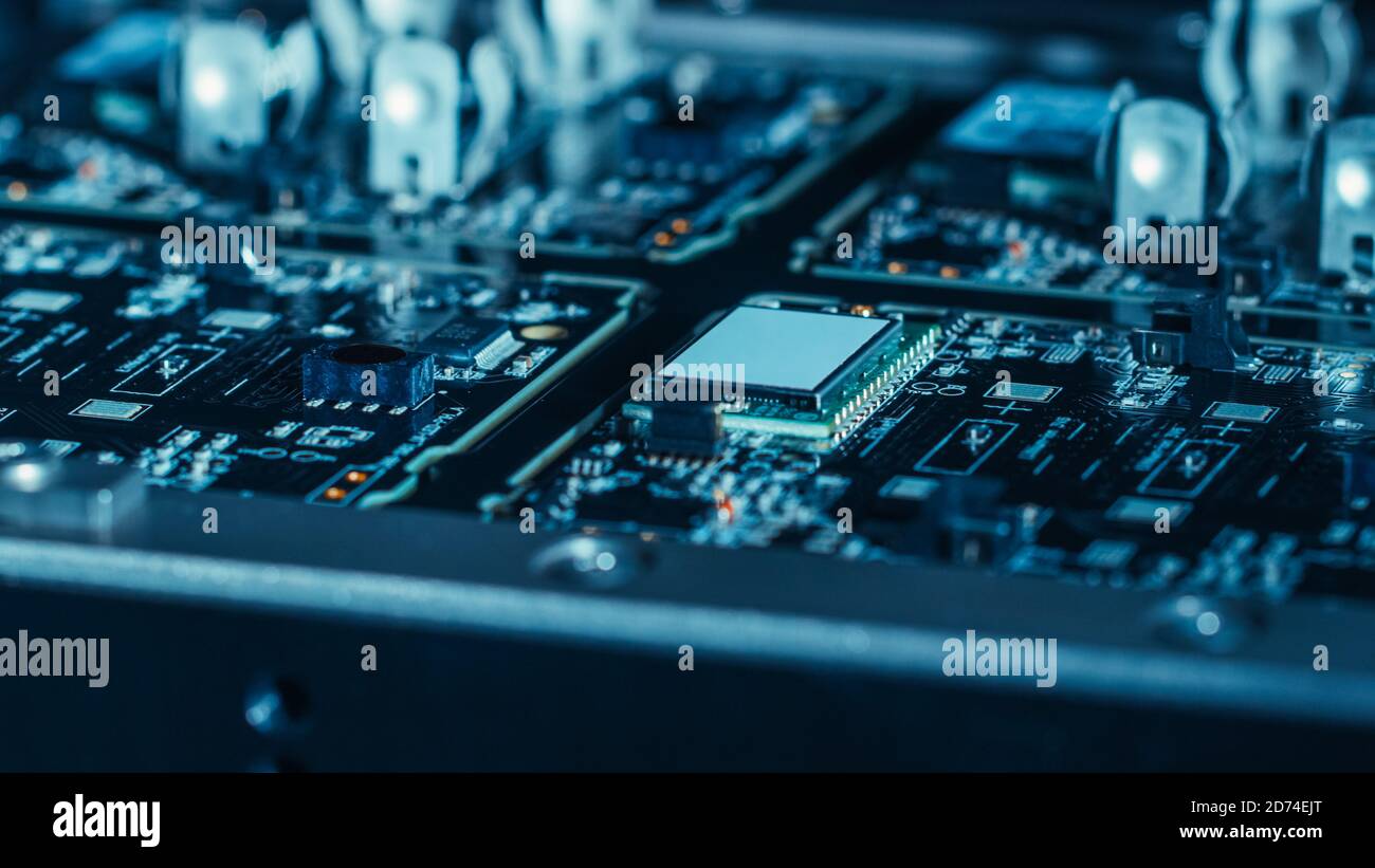 Gros plan d'une machine électronique en usine au travail : carte de circuit imprimé (PCB) en cours d'assemblage avec bras robotique automatisé, montage en surface Banque D'Images