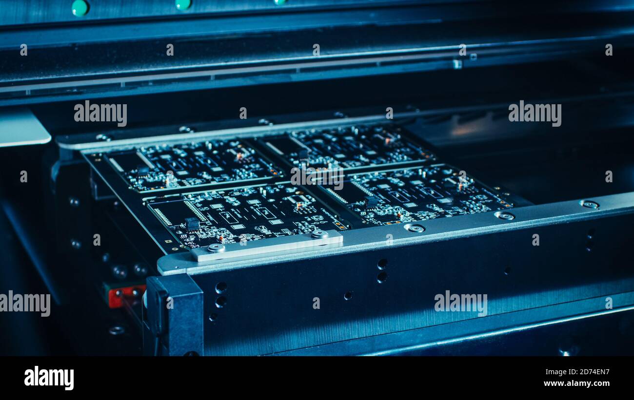 Machine en usine : carte de circuit imprimé en cours d'assemblage avec bras robotisé automatisé, technologie montée en surface connectant les micropuces au Banque D'Images