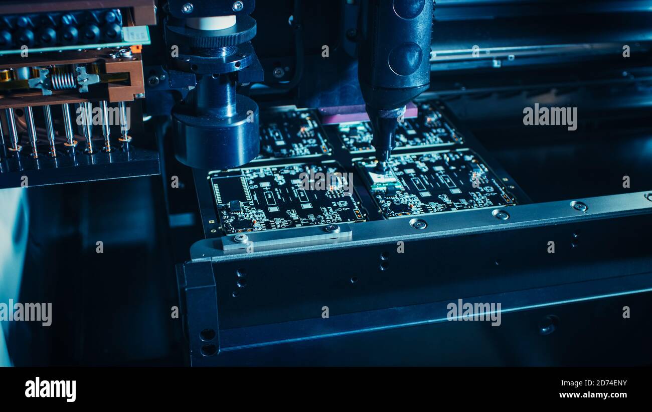 Machine en usine : carte de circuit imprimé en cours d'assemblage avec bras robotique automatisé, technologie montée en surface connectant les micropuces au Banque D'Images