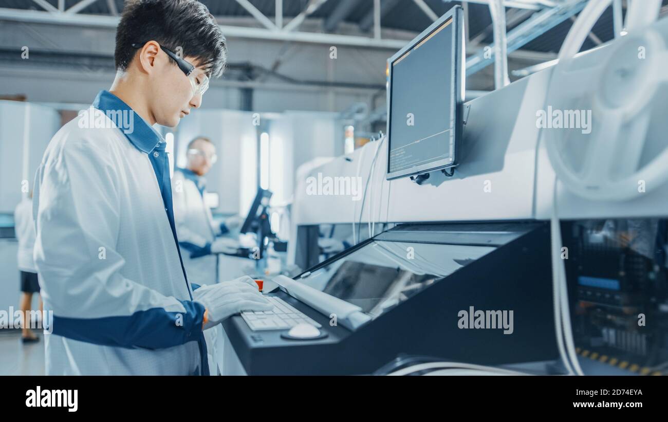 Sur les usines de haute technologie, l'ingénieur asiatique utilise l'ordinateur pour la programmation Choisir et placer les machines électroniques pour l'assemblage de la carte de circuit imprimé Ligne Banque D'Images