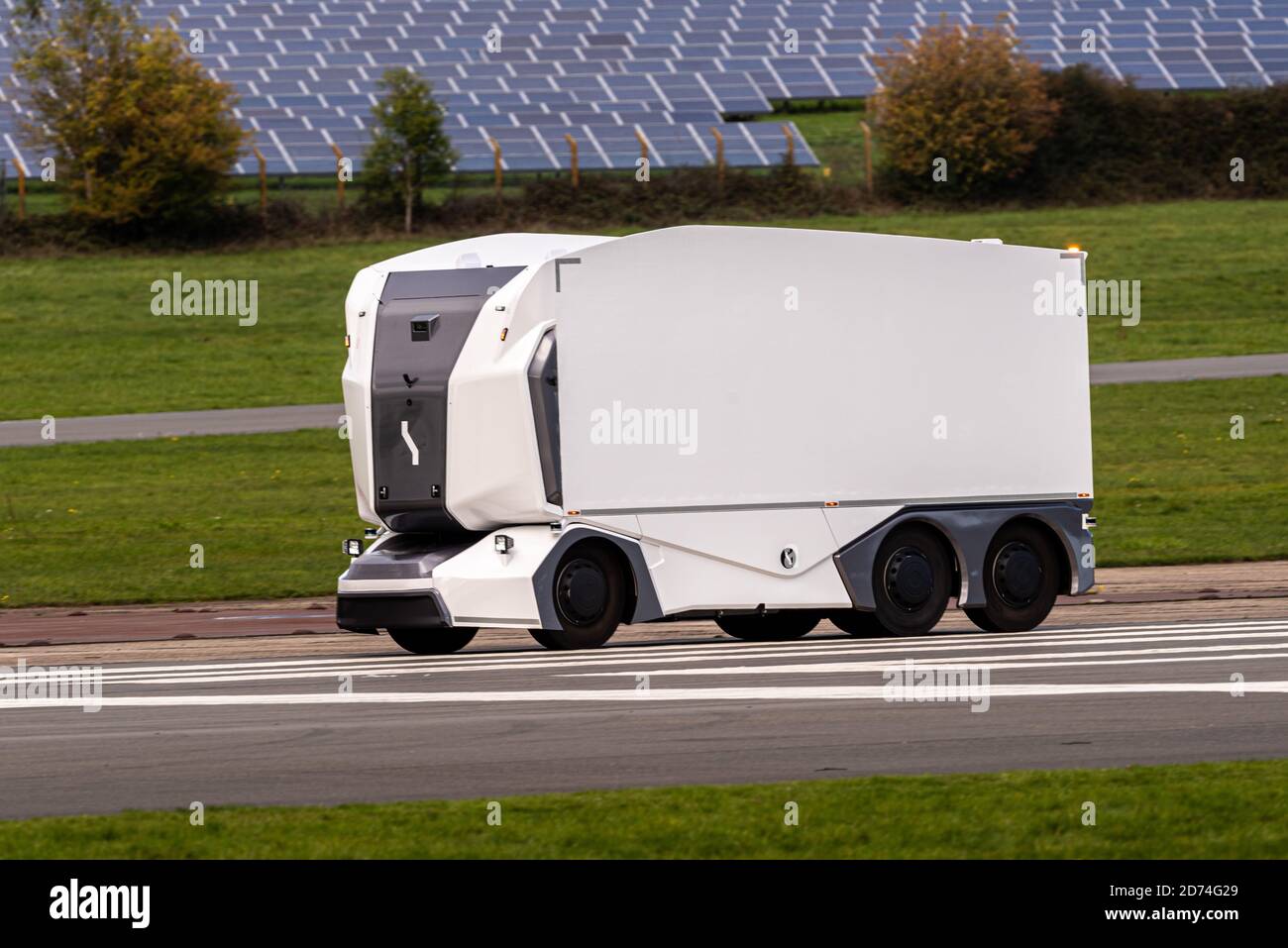 Un camion électrique sans conducteur suédois Einride passe devant des panneaux solaires, piste d'essai Top Gear, aérodrome de Dunsfold, Surrey, Royaume-Uni Banque D'Images