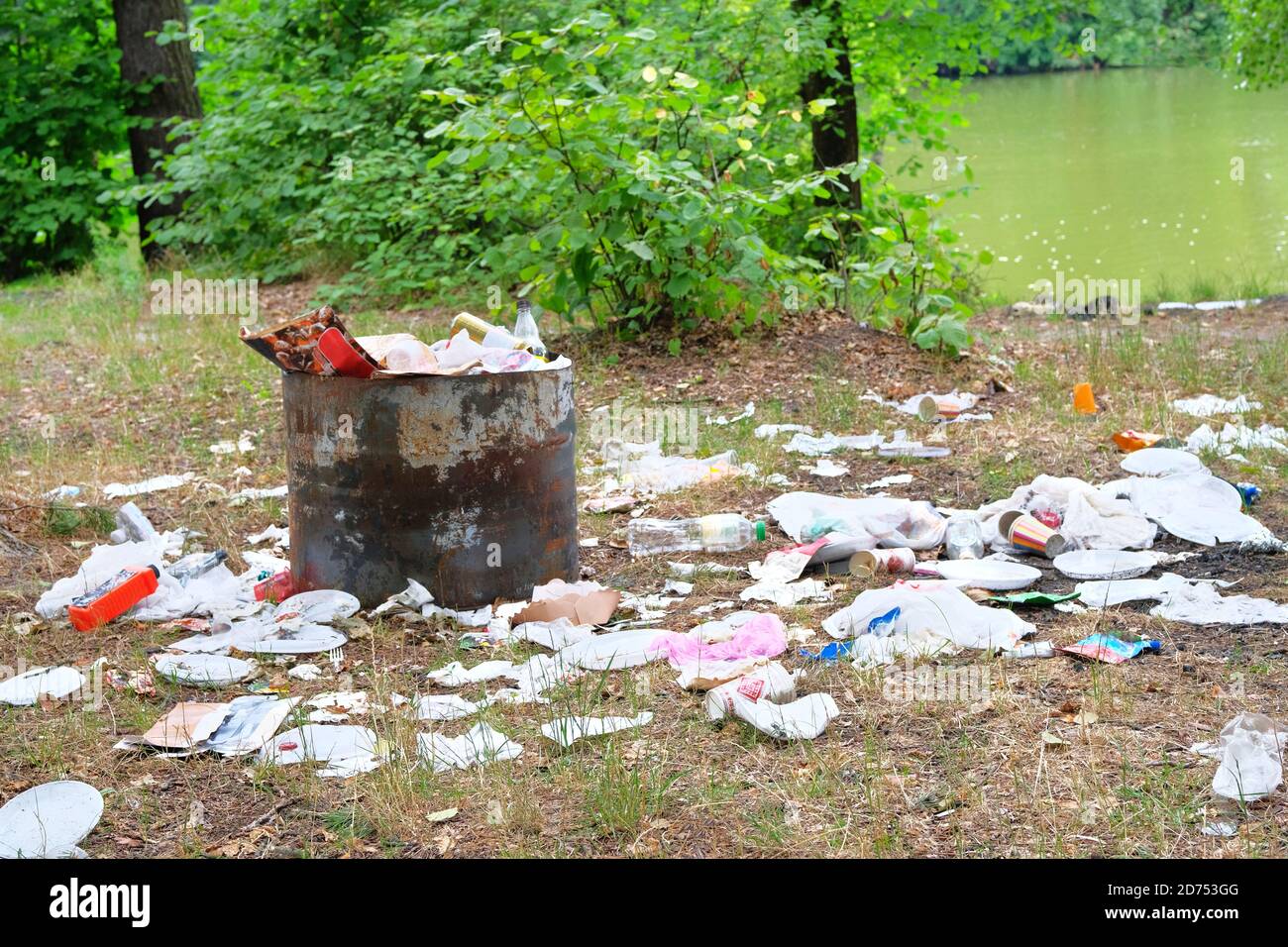 Contamination de la nature par des déchets. Les déchets de plastique et de papier sont en cours de défrichement dans la forêt verte. Concept de pollution de l'environnement. Banque D'Images