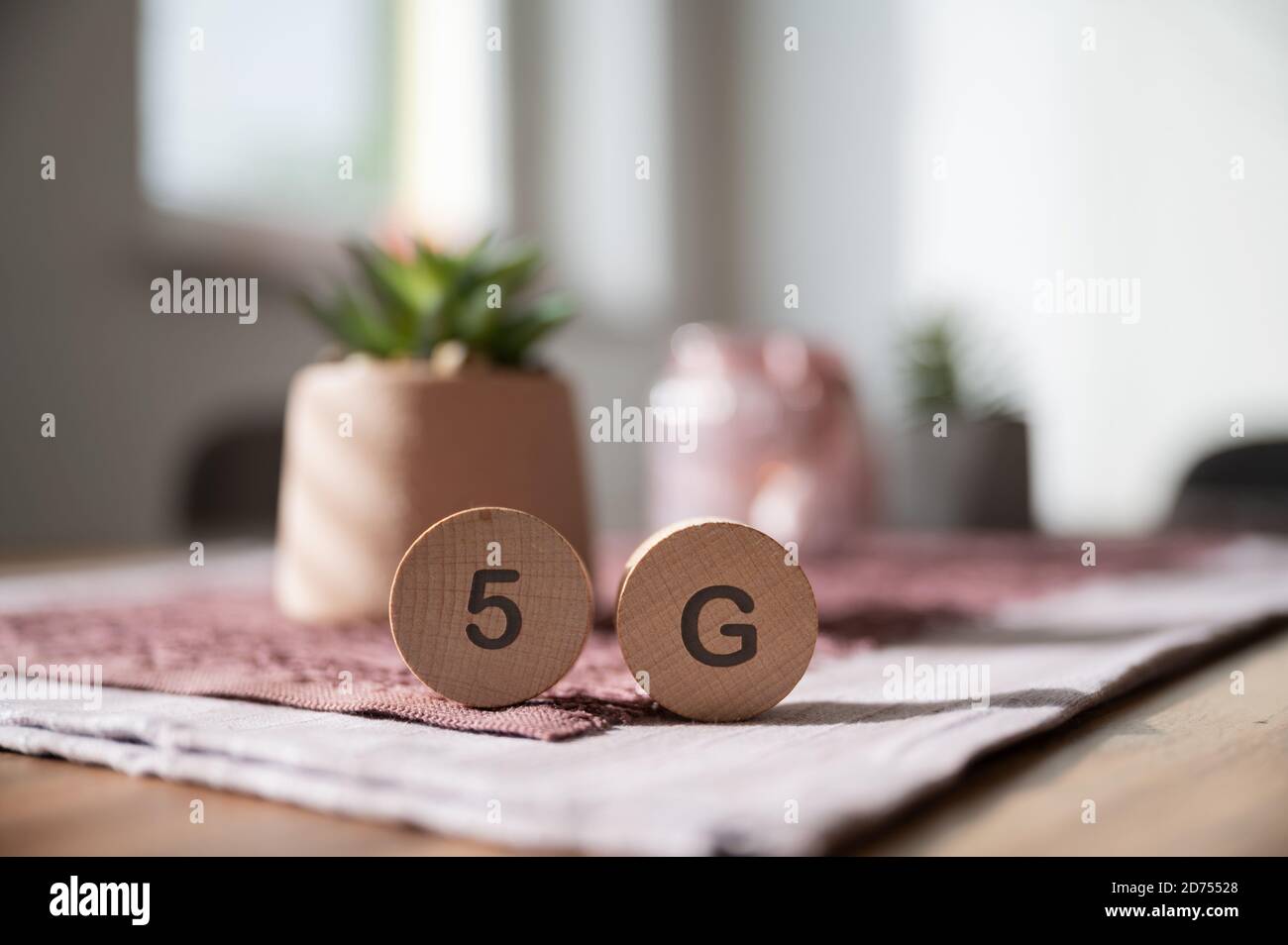 Panneau 5G sur des cercles en bois coupés placés sur une table à manger à la maison. Banque D'Images