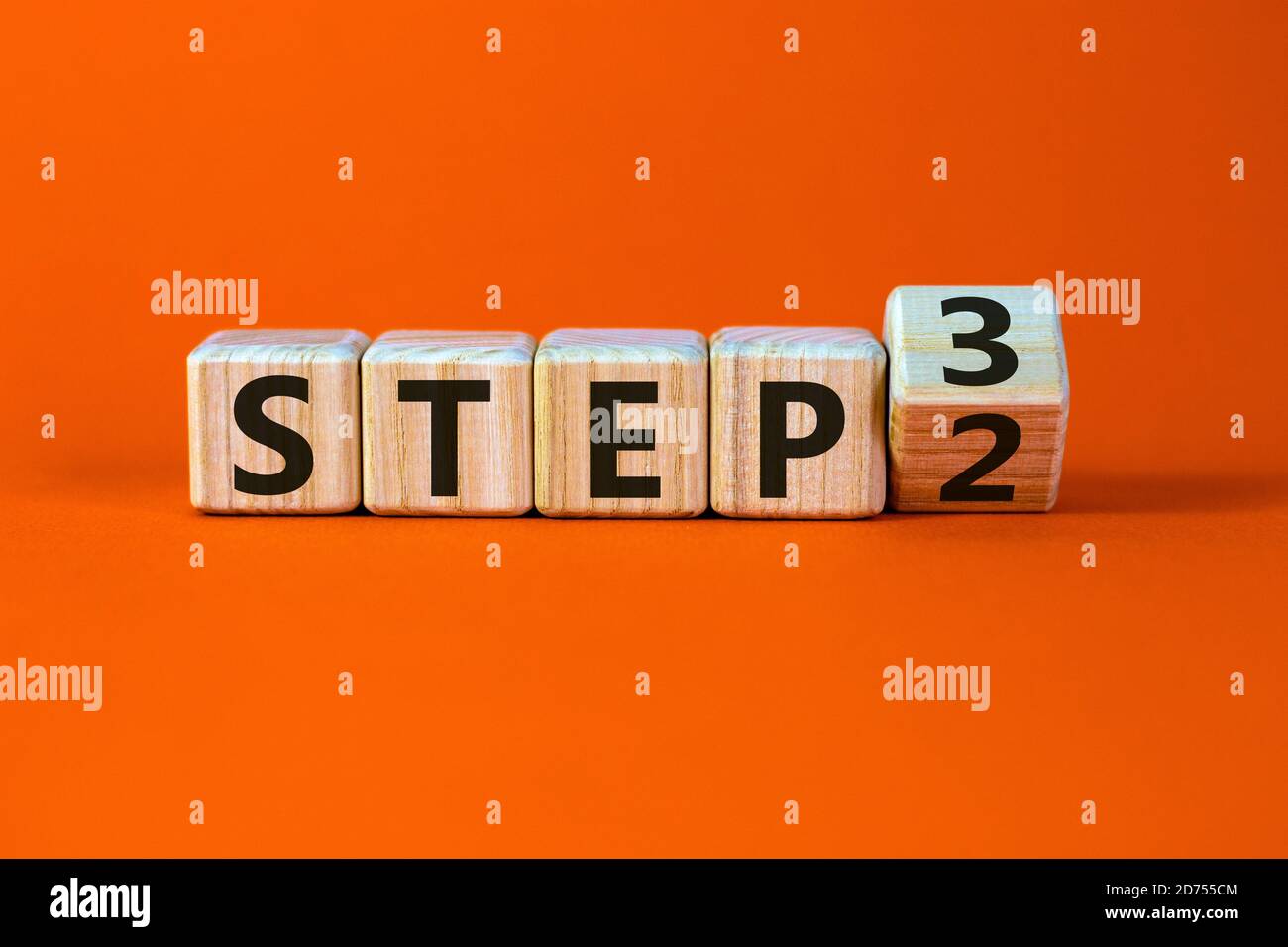 Étape par étape. A tourné un cube et a changé l'expression 'Etape 2' en 'Etape 3'. Magnifique arrière-plan orange. Concept d'entreprise. Copier l'espace. Banque D'Images