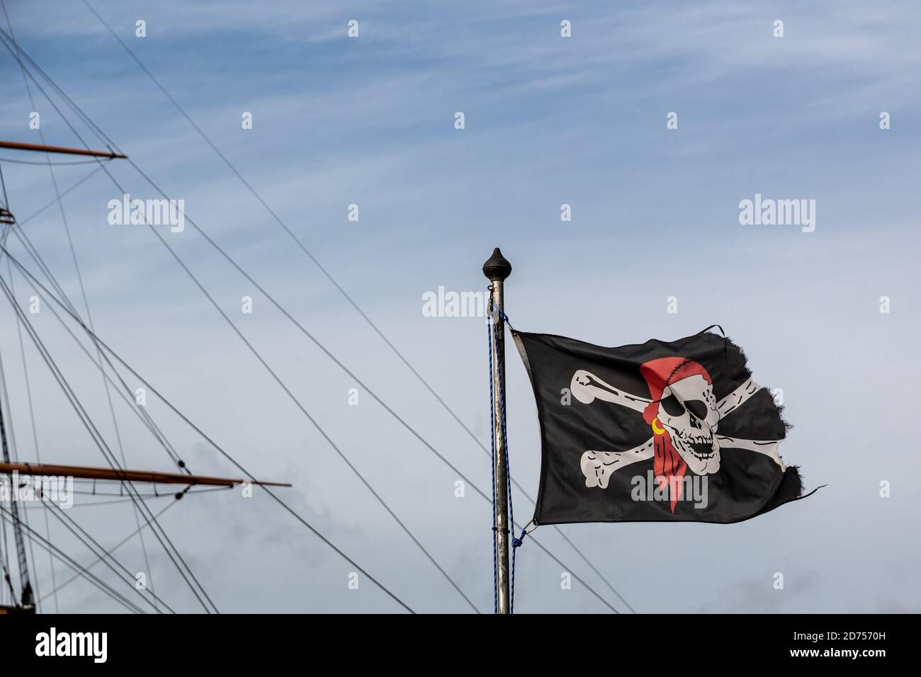 Un drapeau de roger ou de crâne et de crossos de jolly volant à l'intérieur avant du mât d'un ancien navire Banque D'Images